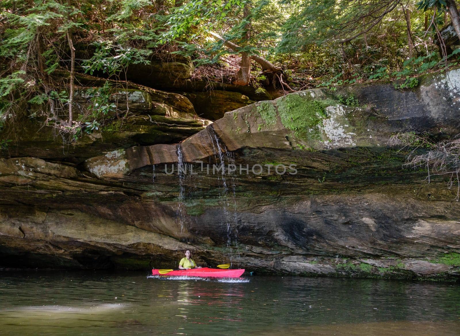 Kayaker behind a small waterfall on Grayson Lake in Kentucky