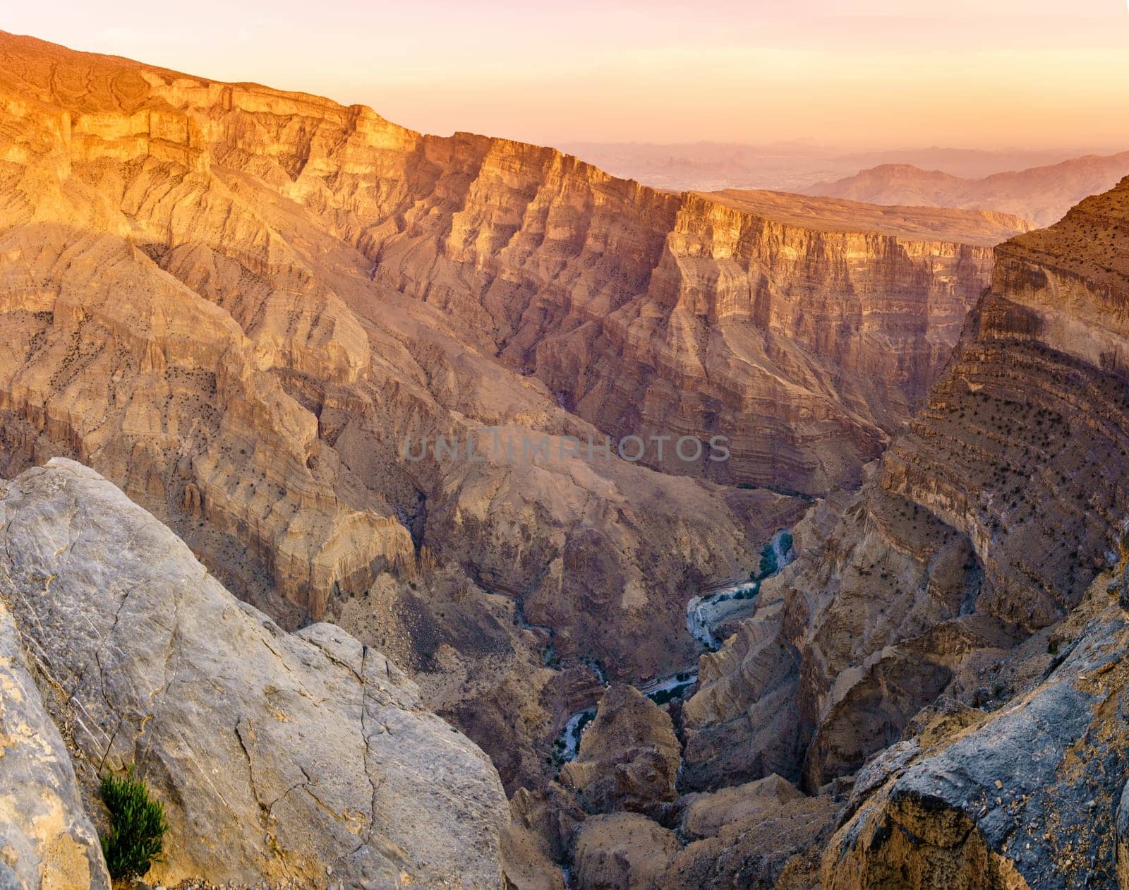 Panoramic view of Wadi Ghul aka Grand Canyon of Arabia in Jebel Shams, Oman at sunset