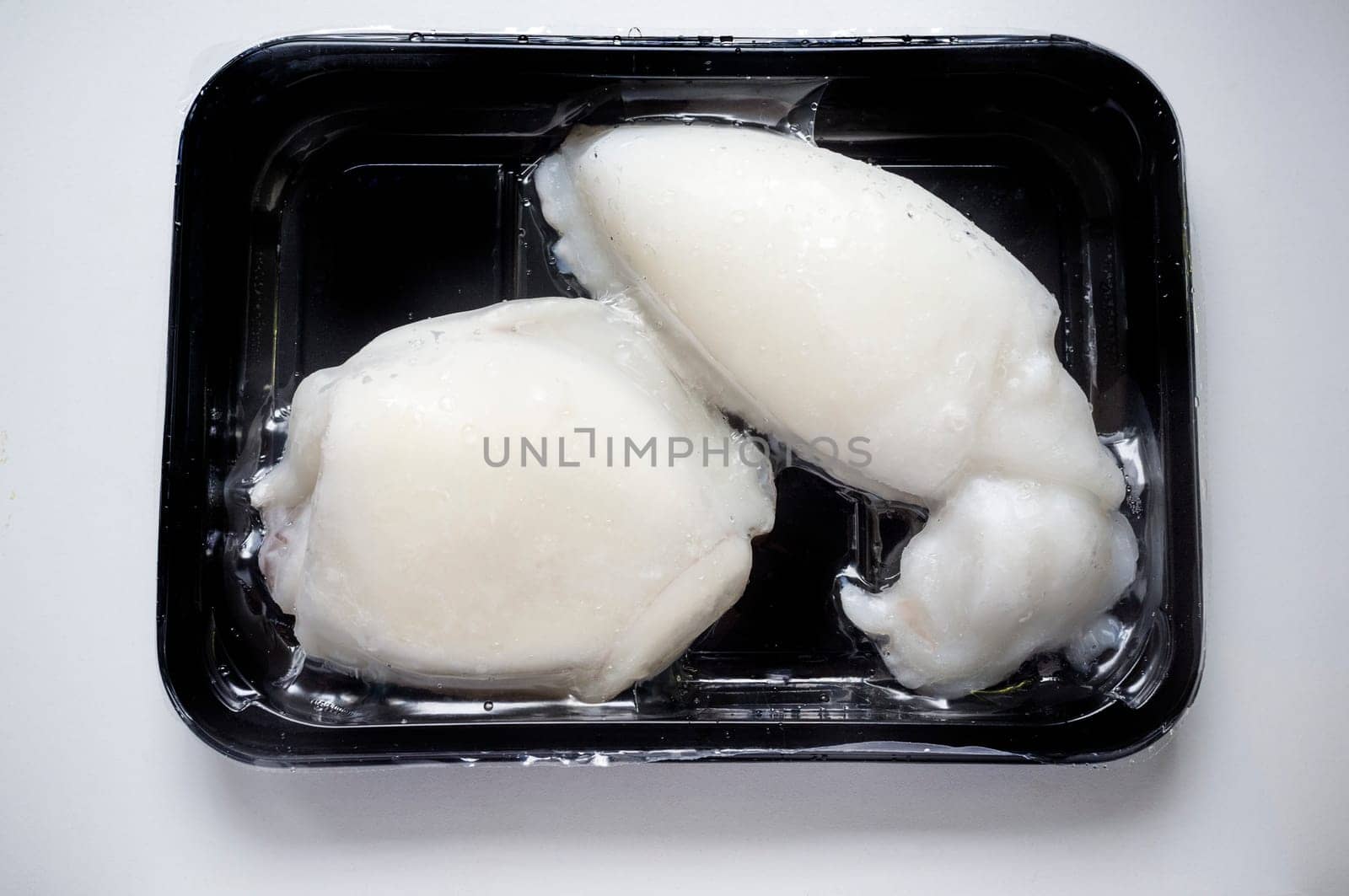 Tray of whole frozen cuttlefish. Overhead shot