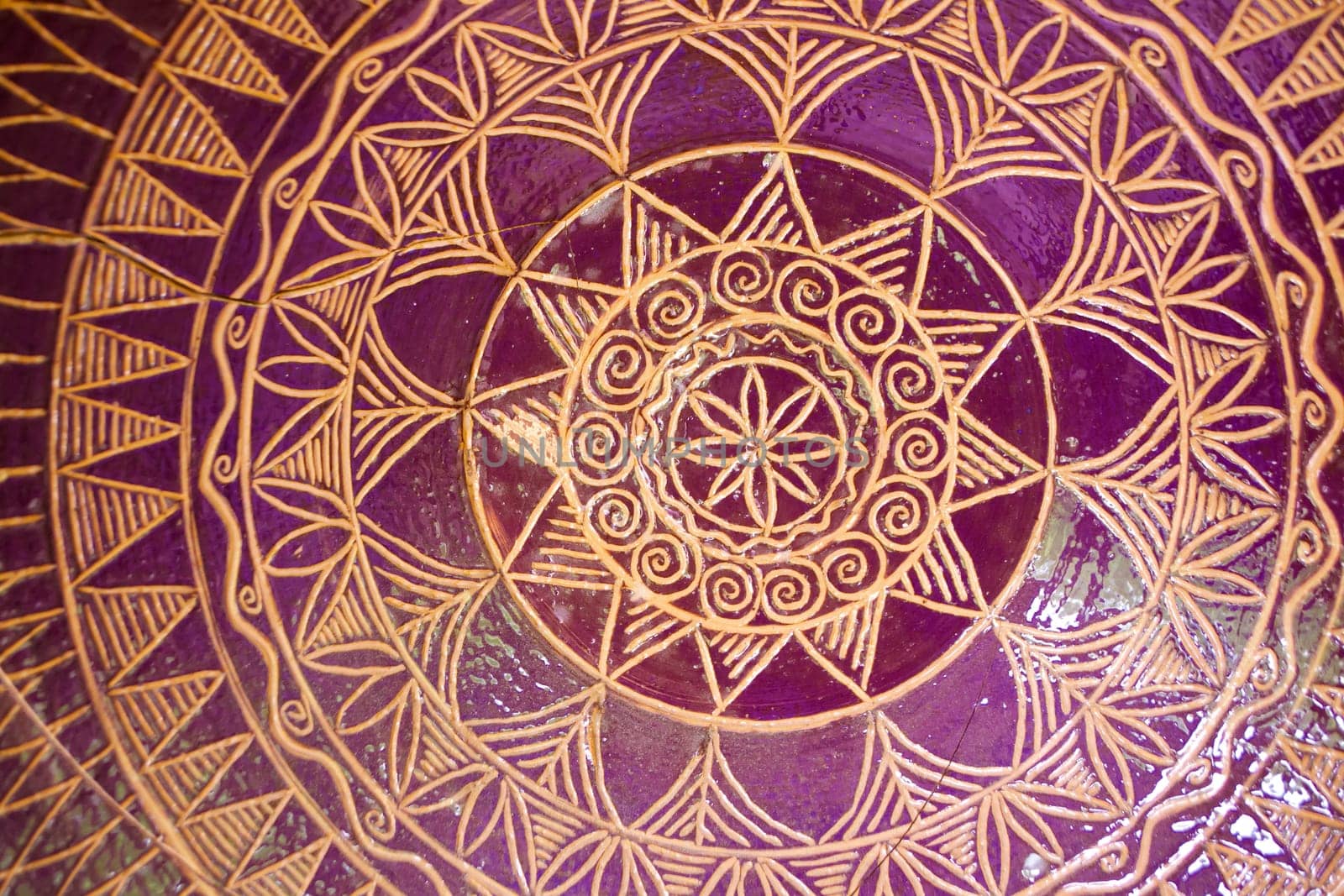 Traditional pattern of tile mandala bowl pottery. Golden and purple colors, close up