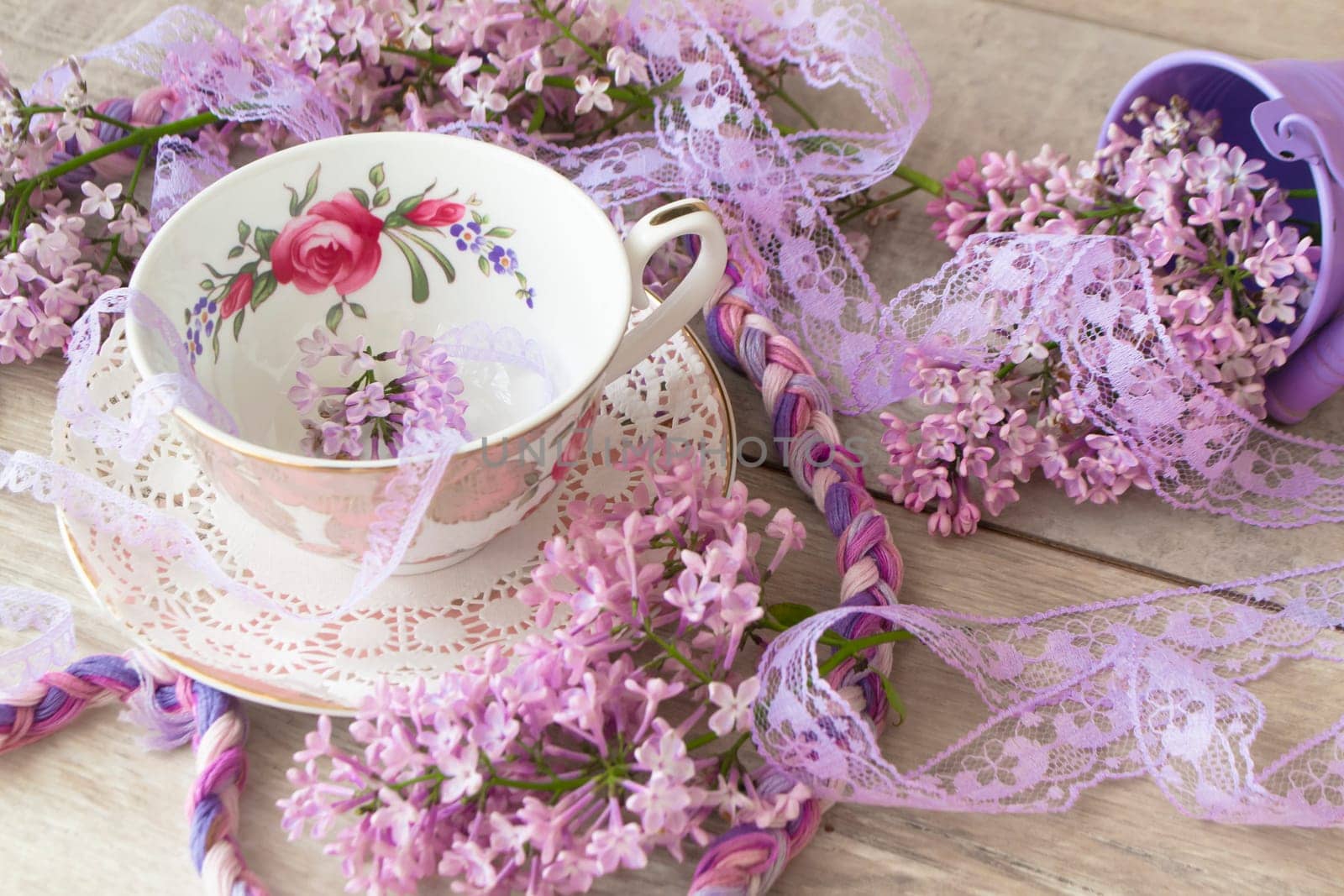 Vintage cup of tea with violet blooming branch of lilac, background for invitation, greeting card design.
