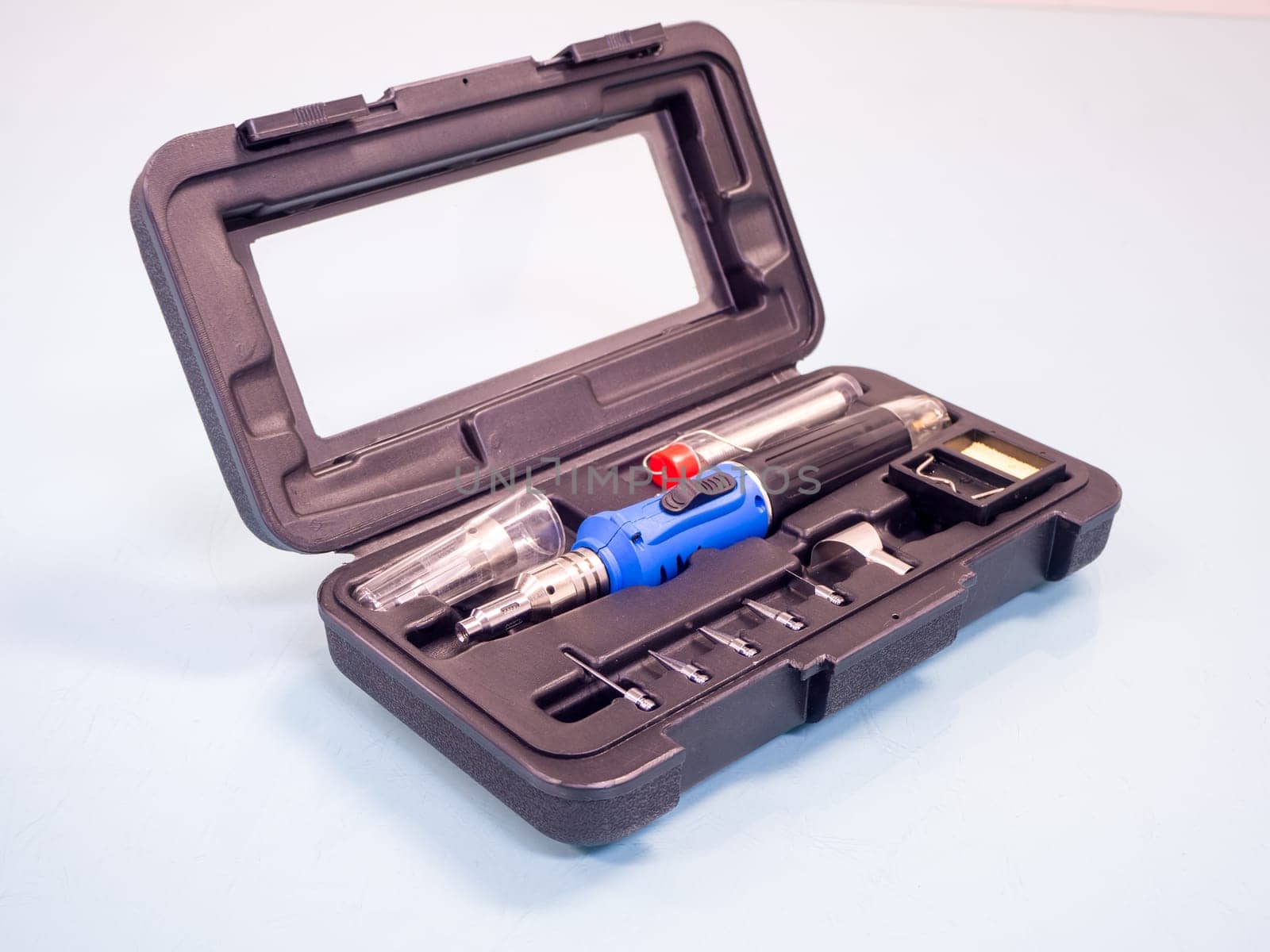 Gas soldering iron in black box isolated on white background.