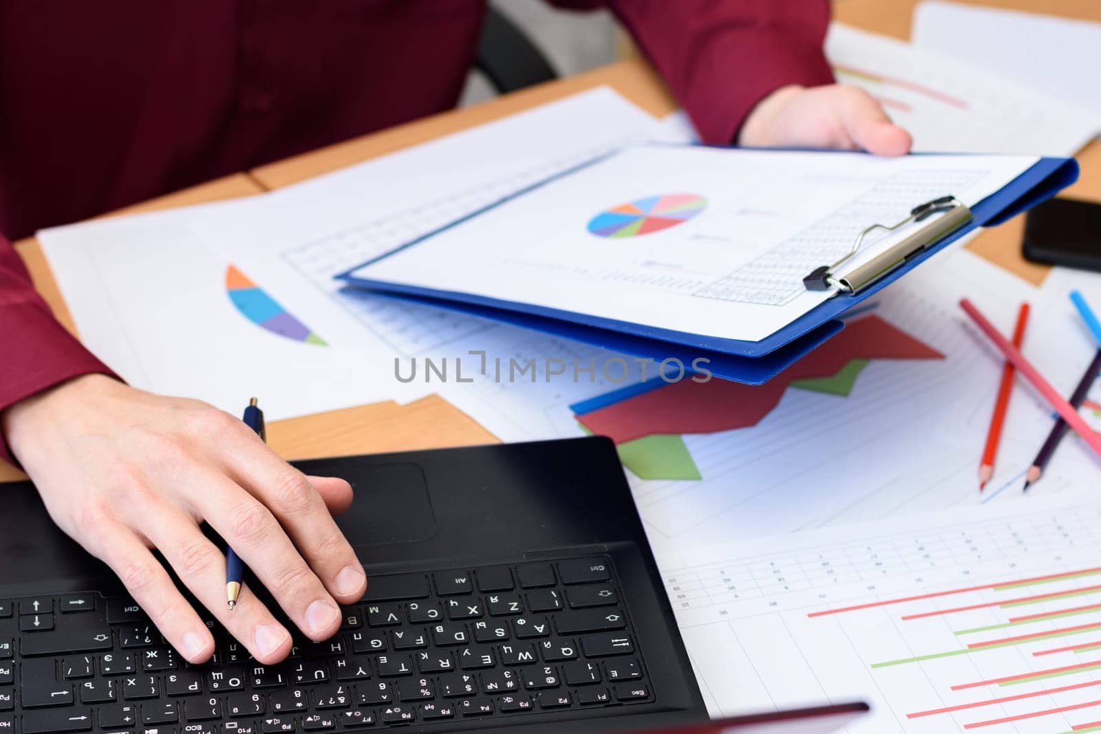 close-up of desktop with documents, laptop, graphs, tables