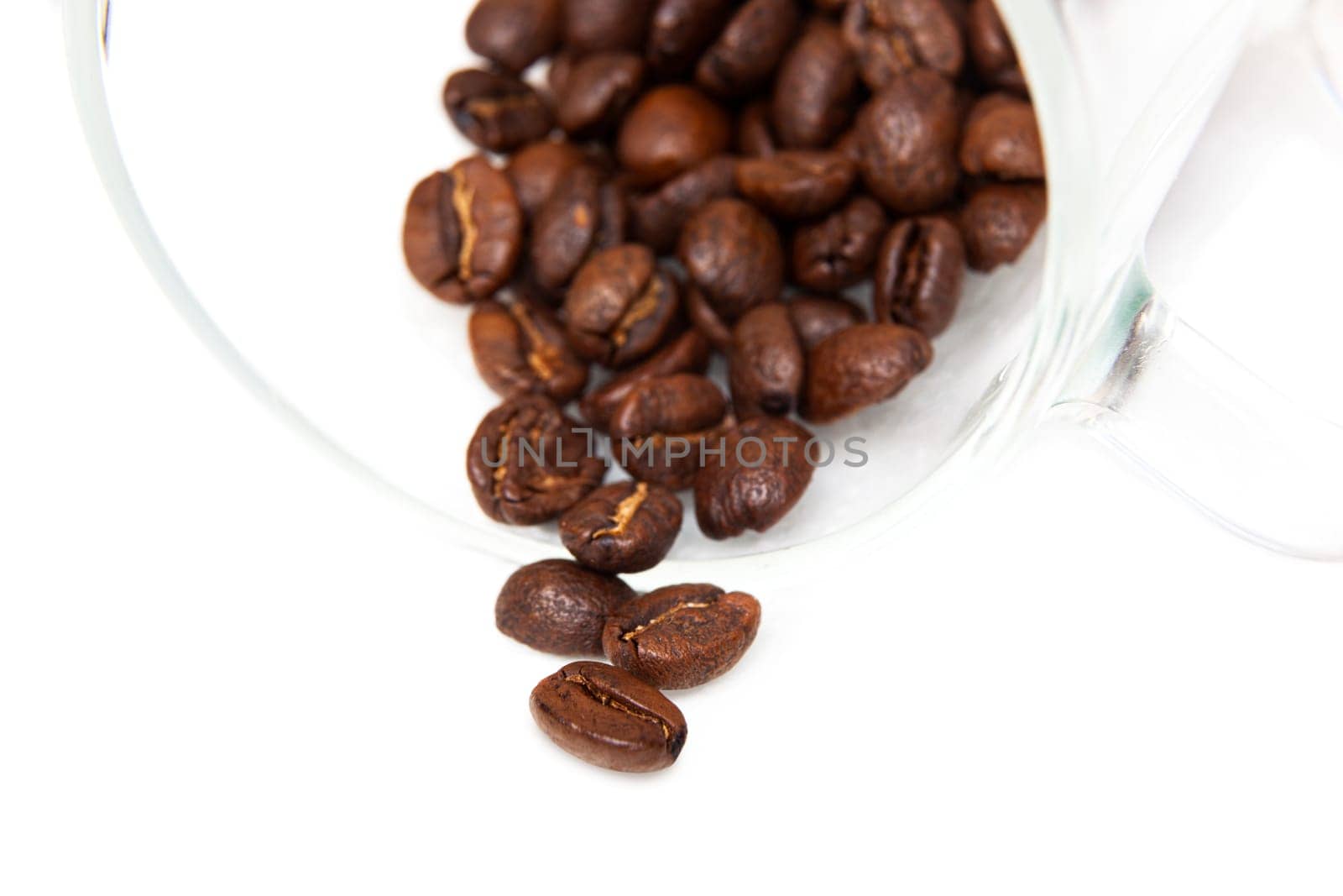Macro capture of coffee beans in a glass cup on white background