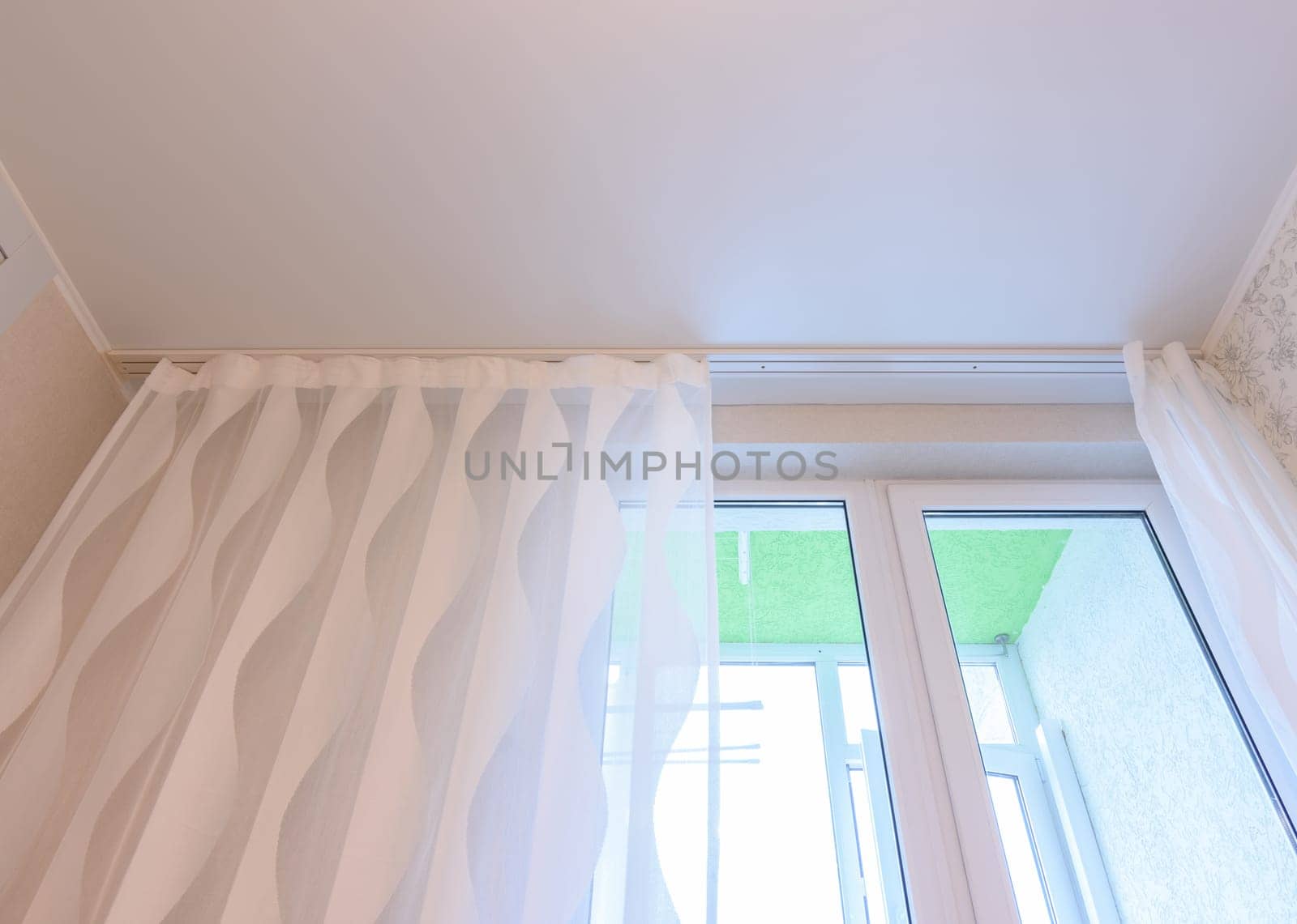 Fragment of the stretch ceiling above the window in the kitchen
