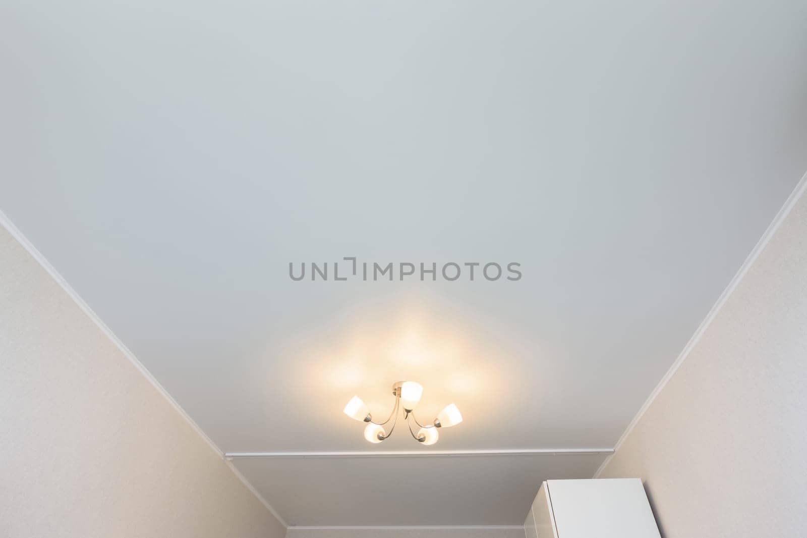 Classic white matte stretch ceiling in the interior of the room