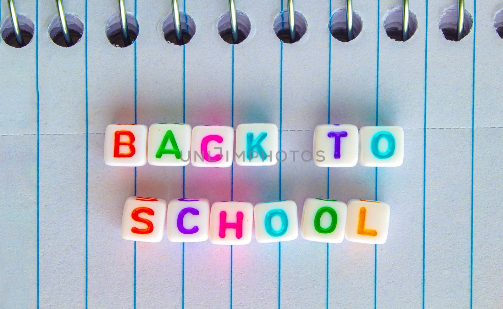 Back to School, message in colorful text on white cubes on a notebook
