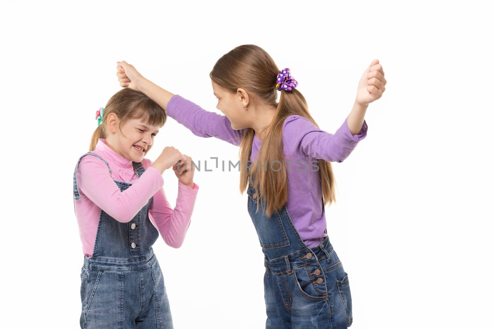 A girl beats another girl on the head
