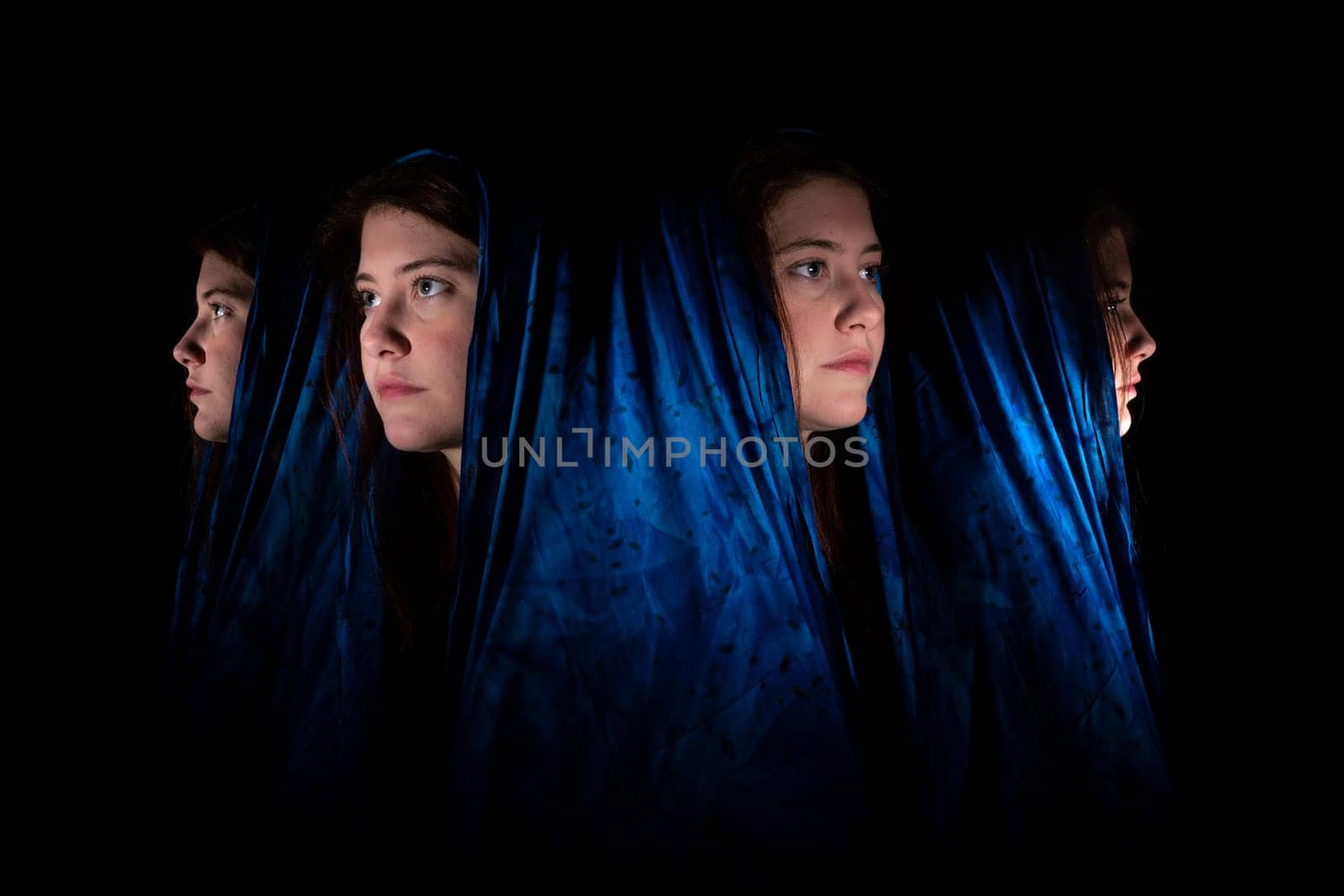 Face of a young woman with a blue headscarf in front and in profile against a black background