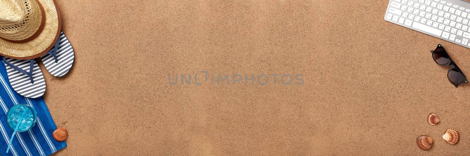 Male beach accessories, glass with cool cocktail and computer keyboard on sand background. Top view with copy space. Concept of sea vacation and travel. Summer background. Travel agency. Internet shop