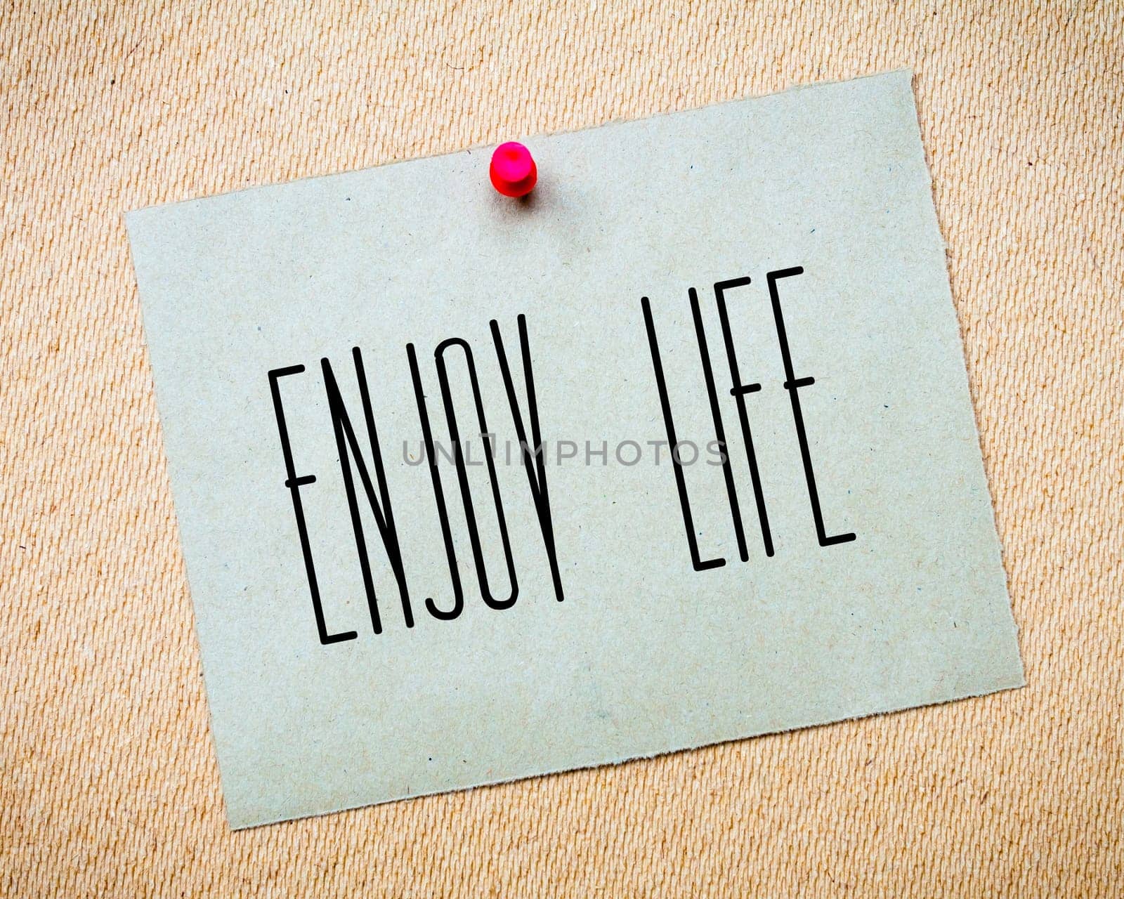 Recycled paper note pinned on cork board.Enjoy Life Message.Happiness Concept Image