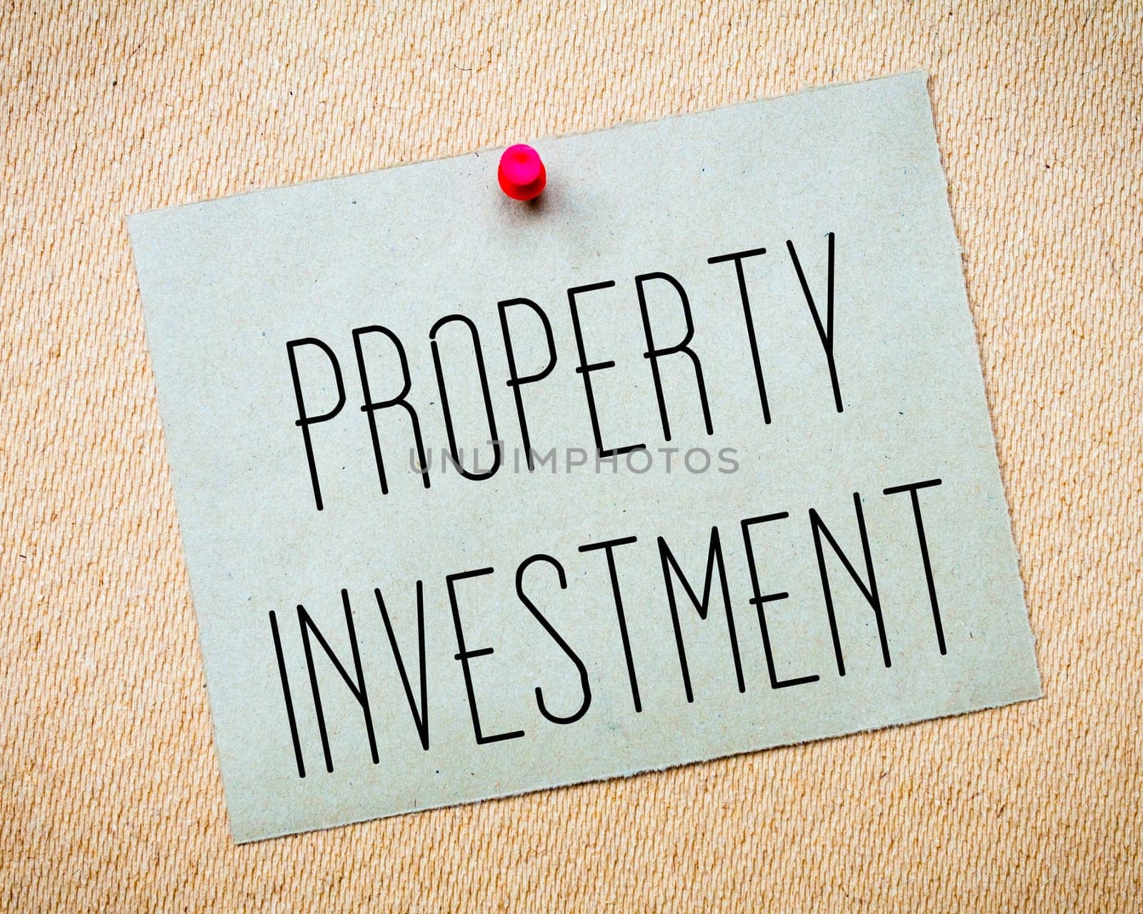 Recycled paper note pinned on cork board.Property Investment Message. Business Concept Image