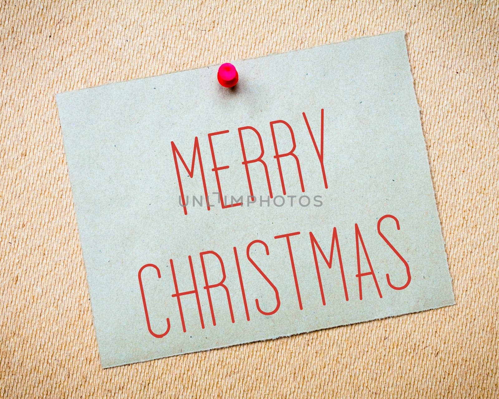 Recycled paper note pinned on cork board.Merry Christmas Message. Concept Image