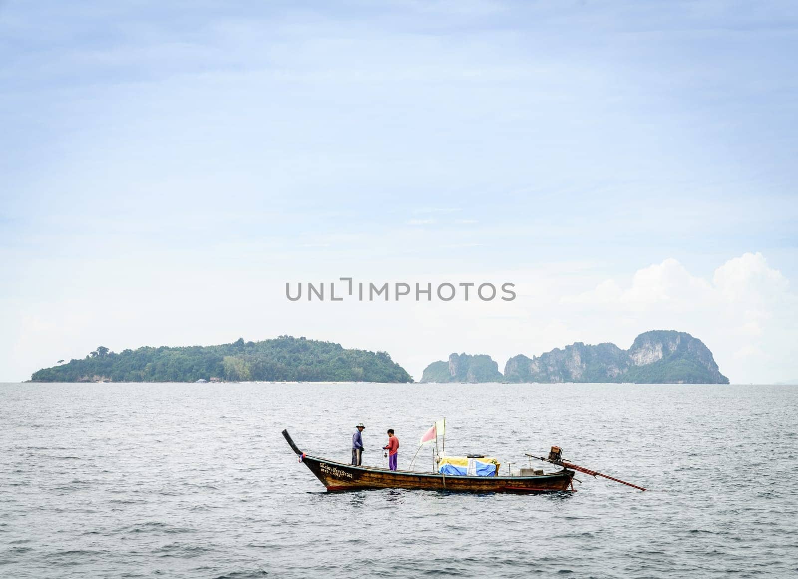 Krabi, Thailand, November 9, 2017: Thai long tail fishing boat in the Andaman Sea with islands on the horizon