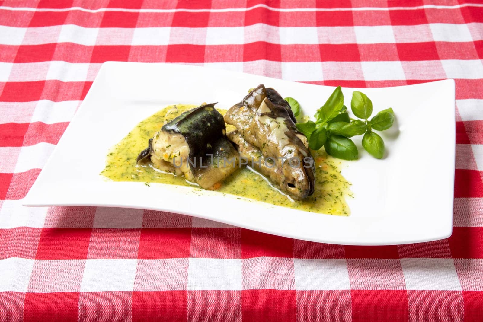 Freshly caught eel from the Havel river in Potsdam (Germany) was cooked in a broth of vegetables, greens, spices and white wine and served on a porcelain plate with a dill sauce. Healthy food.