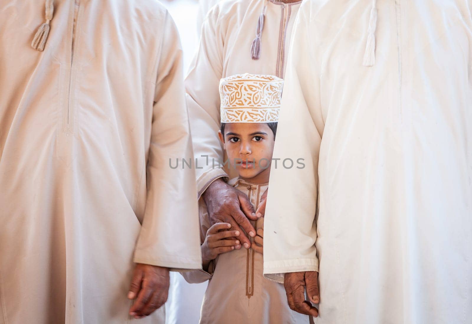 Nizwa, Oman, December 2, 2016: Portrait of a local boy in traditional clothes at the Friday goat market in Nizwa, Oman
