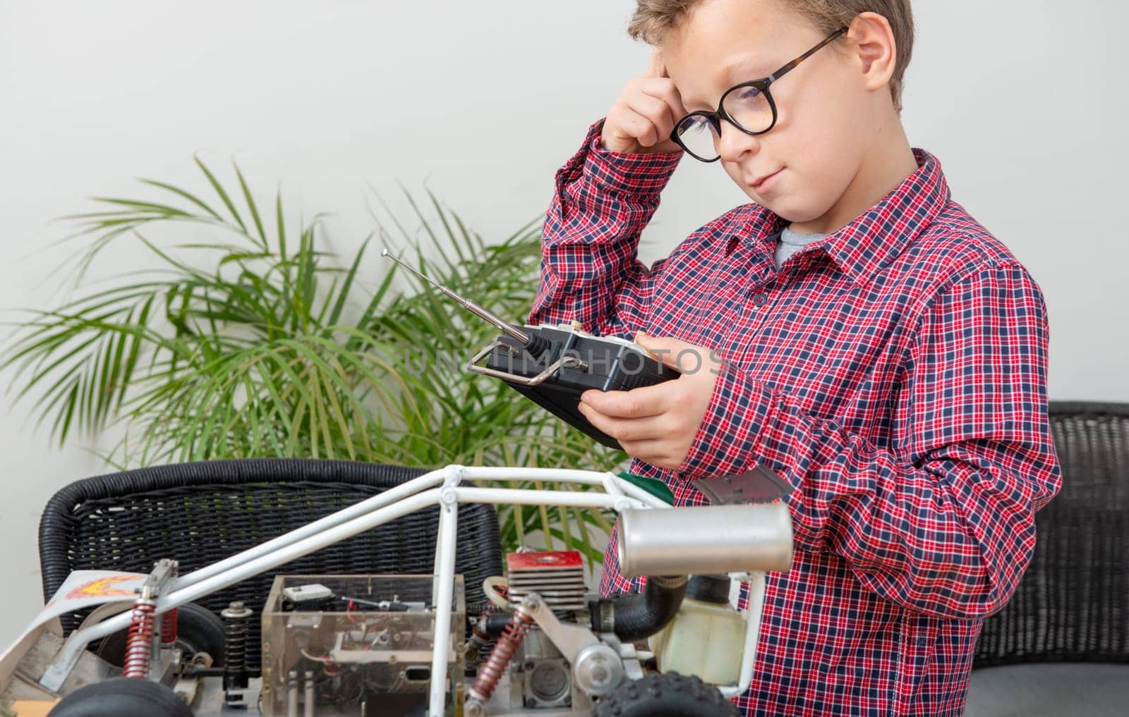 a little boy repairing a model radio-controlled car at home