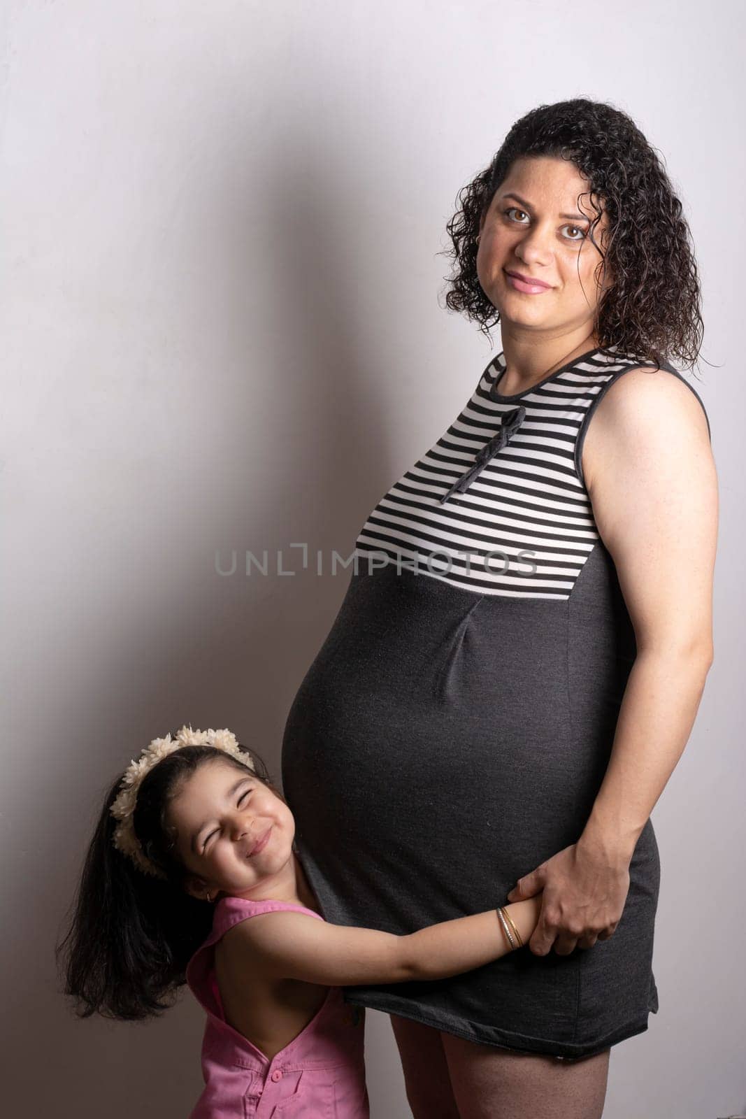 A young beautiful pregnant mother with her two years old daughter, Parenthood and kid’s relationship concept