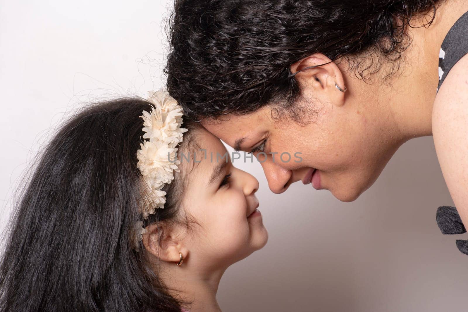 Loving mother and daughter with heads together, happy family or mother's day concept