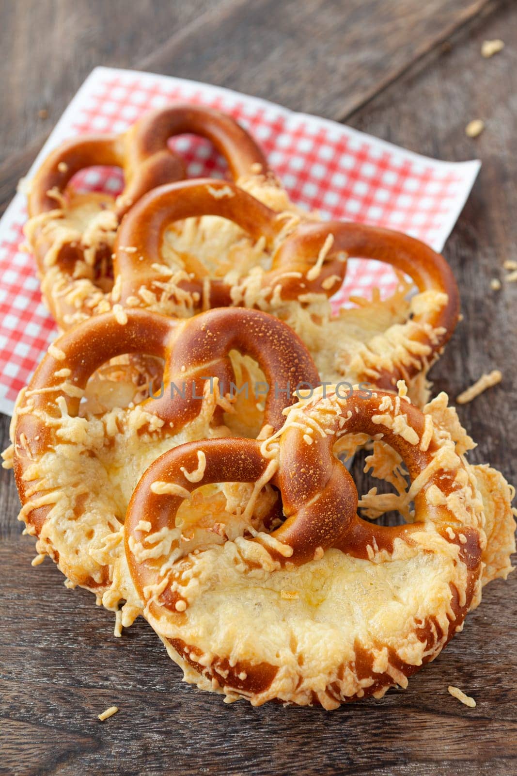 Delicious soft pretzels with cheese on a wooden background