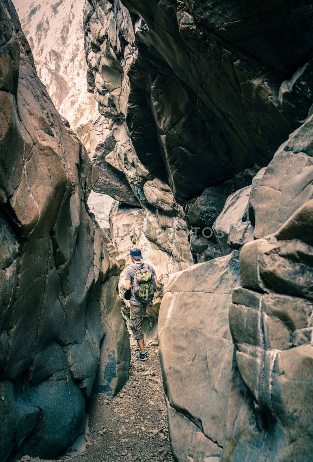 A man is hiking through a wadi in Hajar Mountains near Hatta, UAE