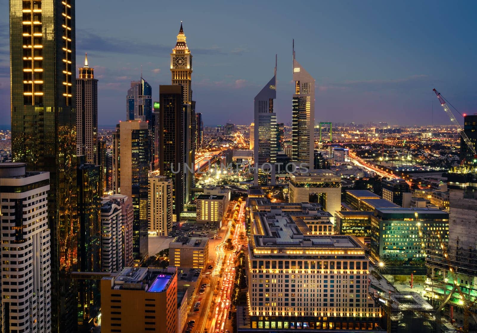 Bird's eye view of Dubai Financial District skyline and rush hour traffic after sunset