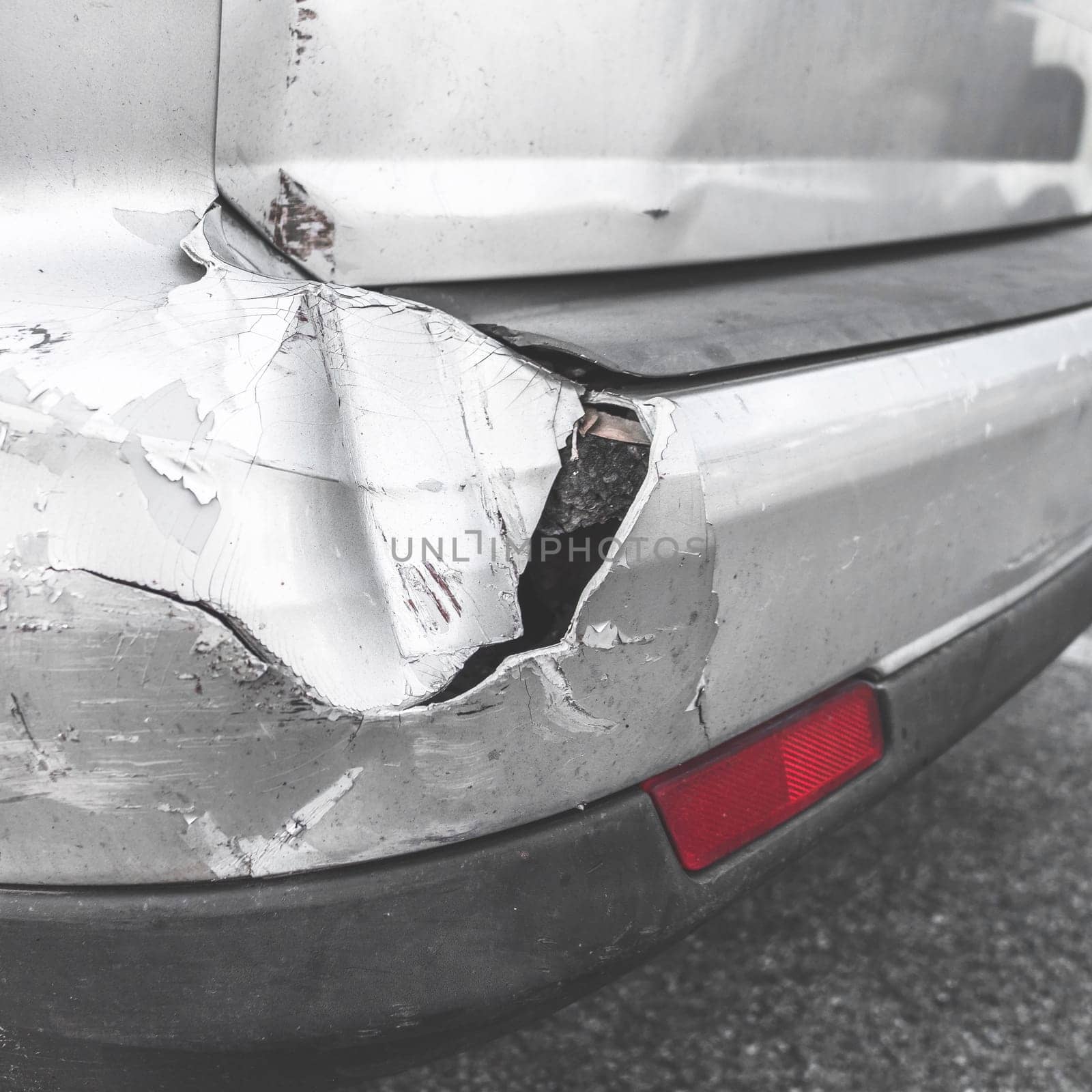 Damaged car. Road accident. Back of gray car get damaged from accident on the road. Vehicle bumper dent  broken by car crash. Retro style photo.