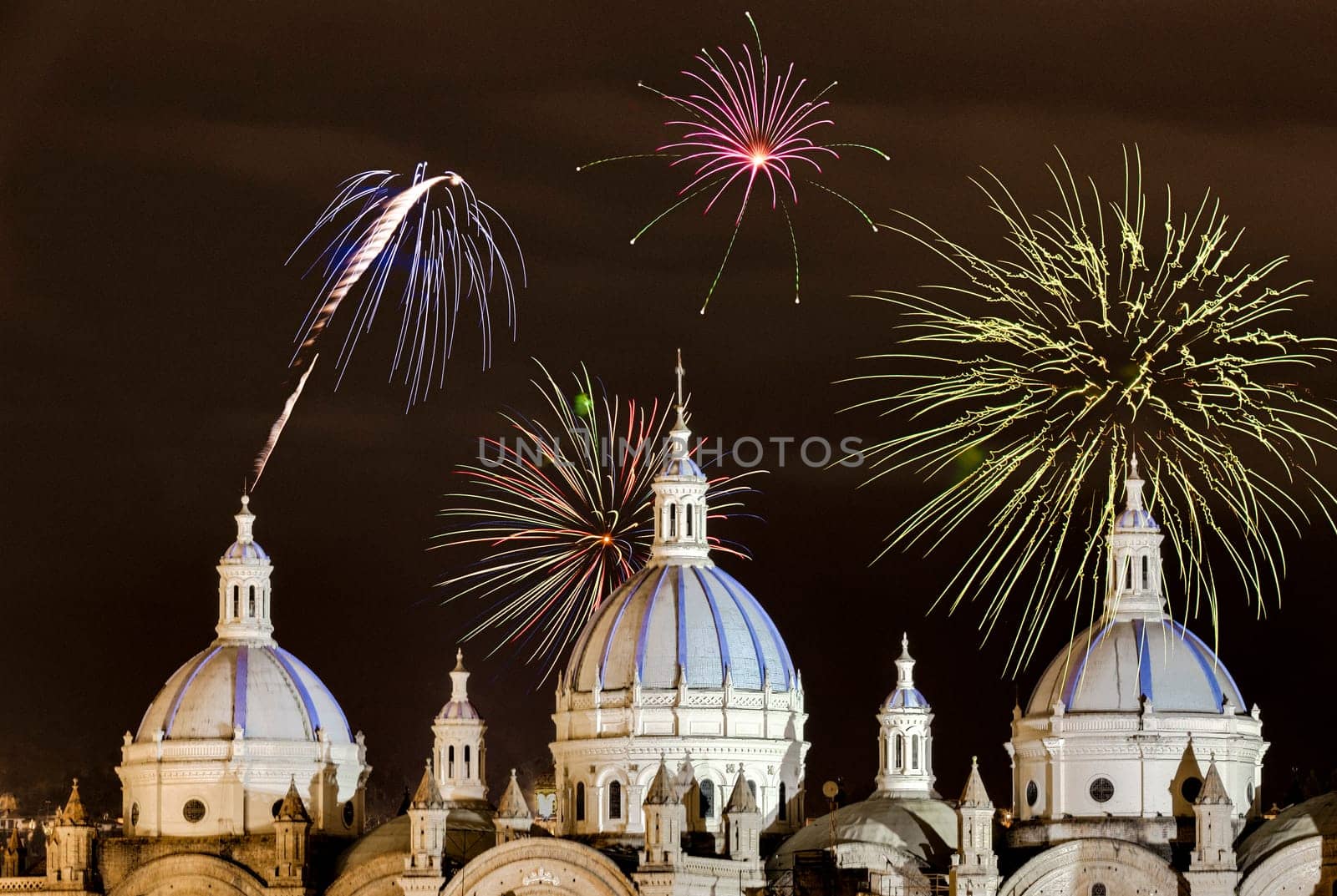 Fireworks over the domes of the New Cathedral in Cuenca, Ecuador. These are the famous view that are usually found on all travel brochures for the city.