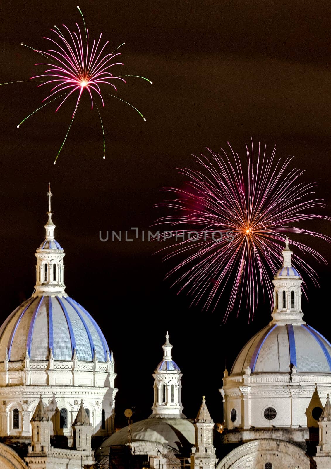 Fireworks over the domes of the New Cathedral in Cuenca, Ecuador. These are the famous view that are usually found on all travel brochures for the city.