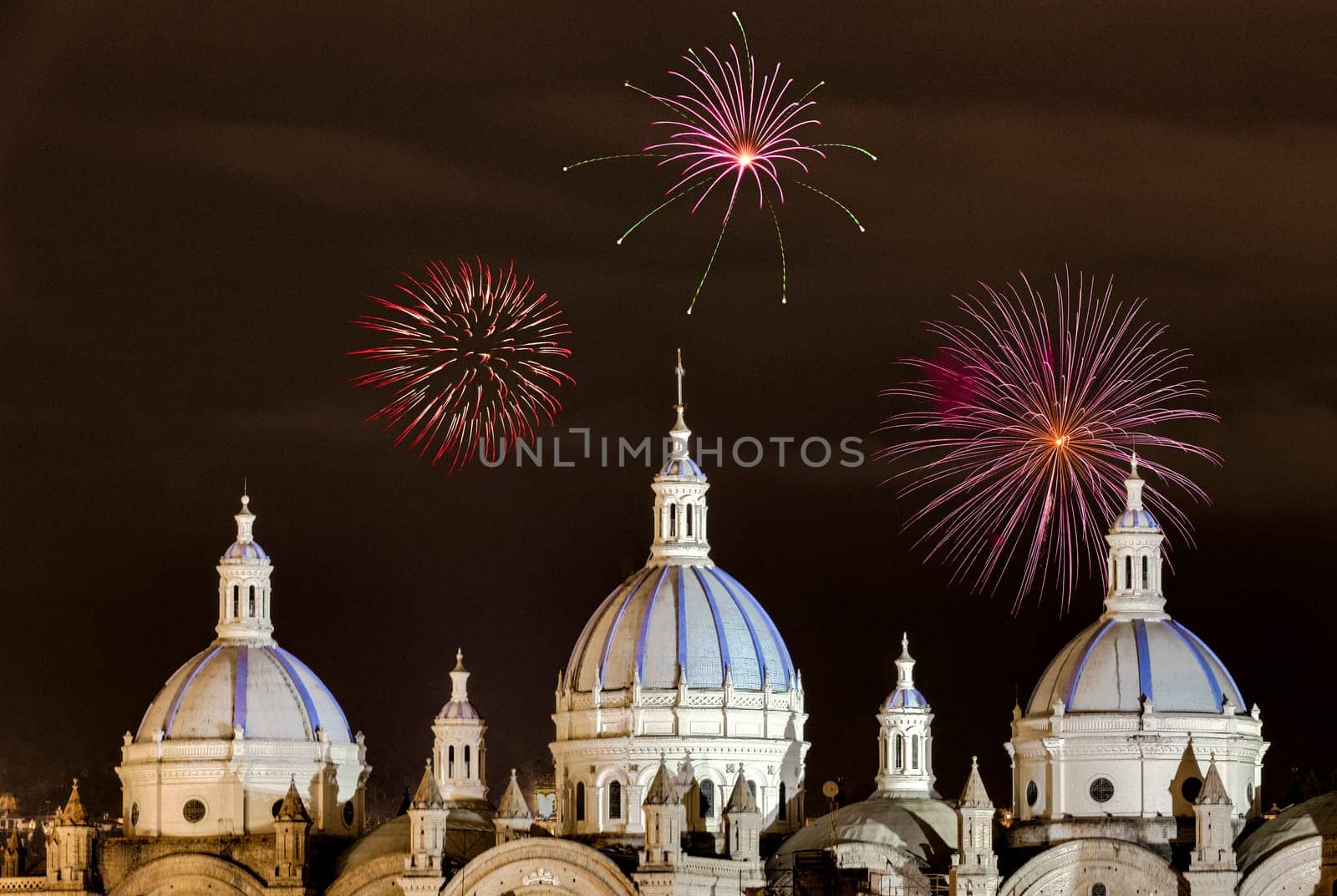 Fireworks over the domes of the New Cathedral in Cuenca, Ecuador. These are the famous view that are usually found on all travel brochures for the city.