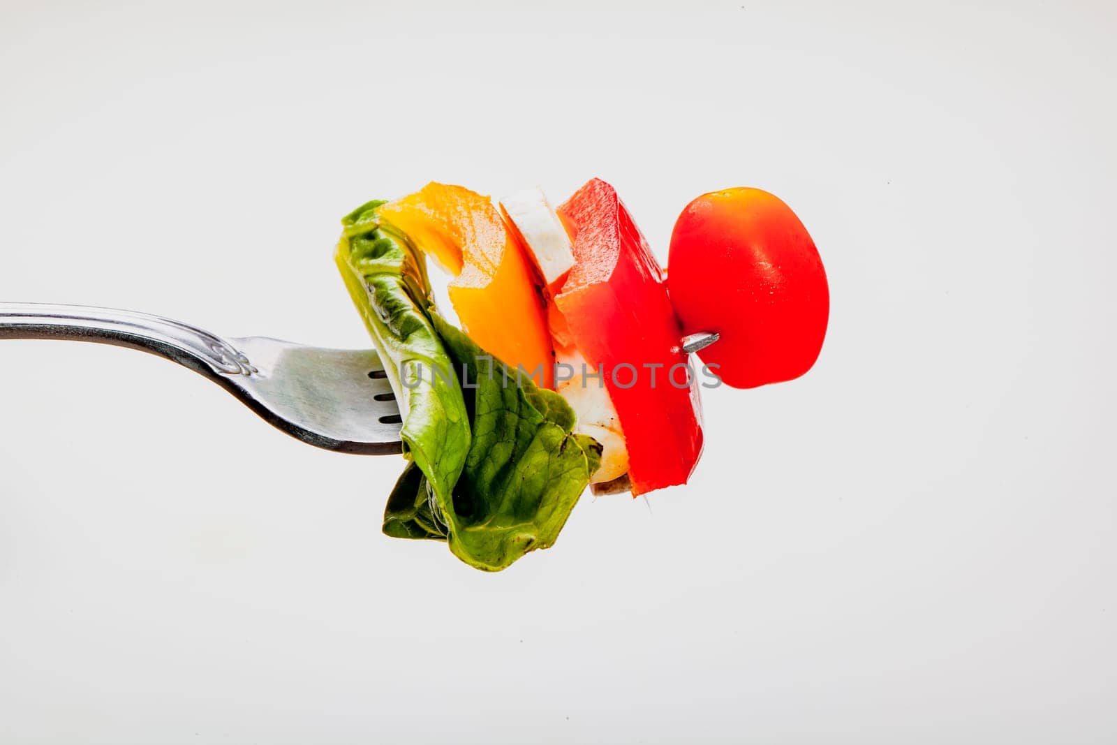 Salad on a fork on white background