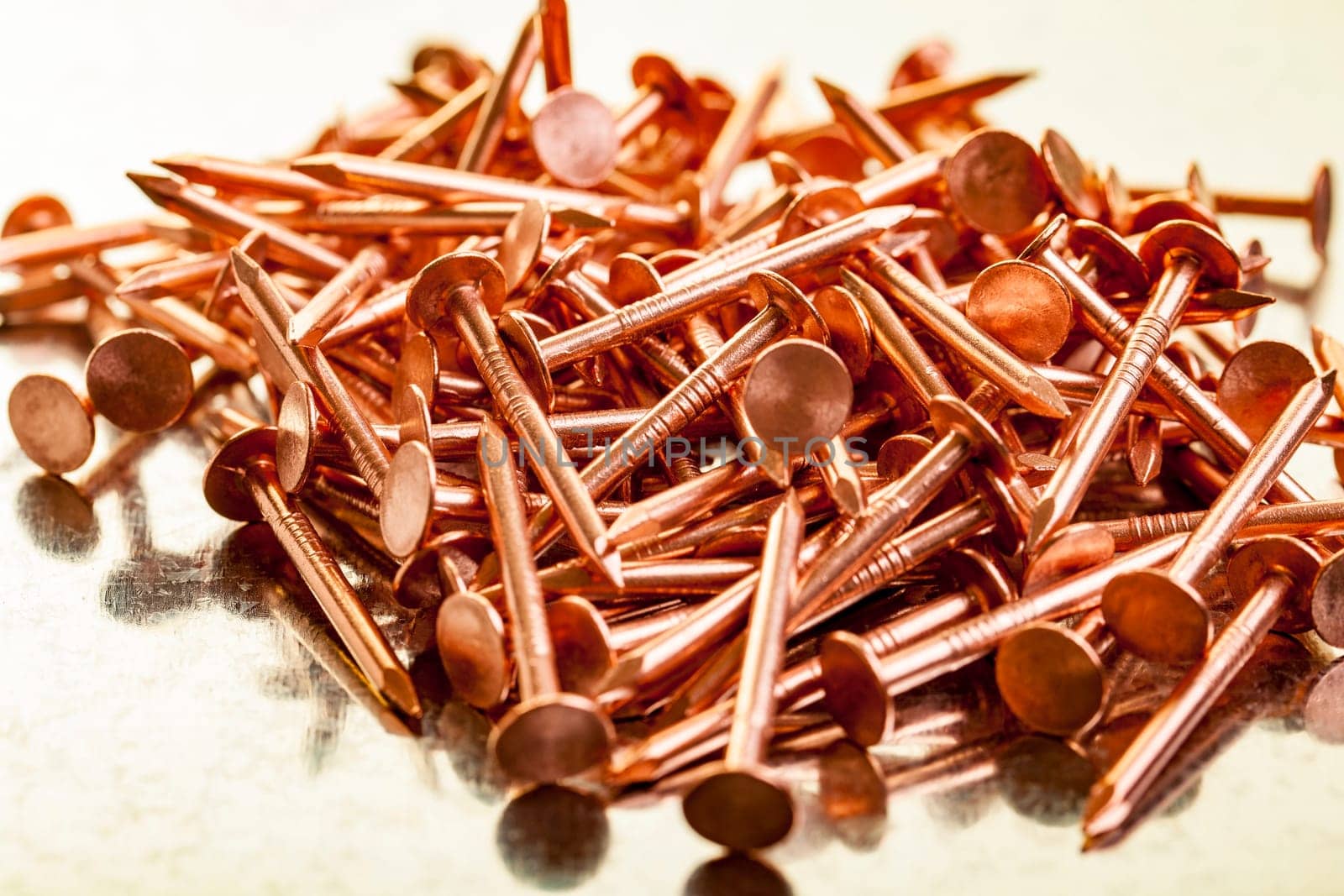 Pile of copper nails on a galvanized steel table