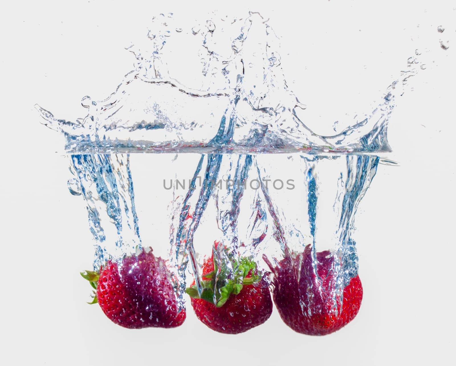 Ripe Strawberries Dropping Into Water