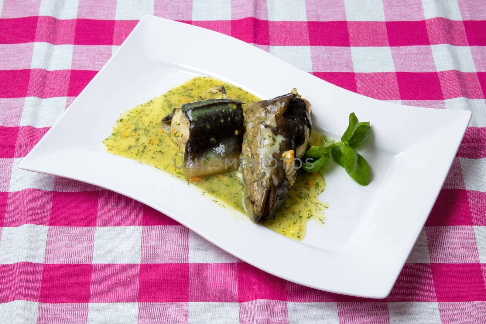 Freshly caught eel from the Havel river in Potsdam (Germany) was cooked in a broth of vegetables, greens, spices and white wine and served on a porcelain plate with a dill sauce. Healthy food.