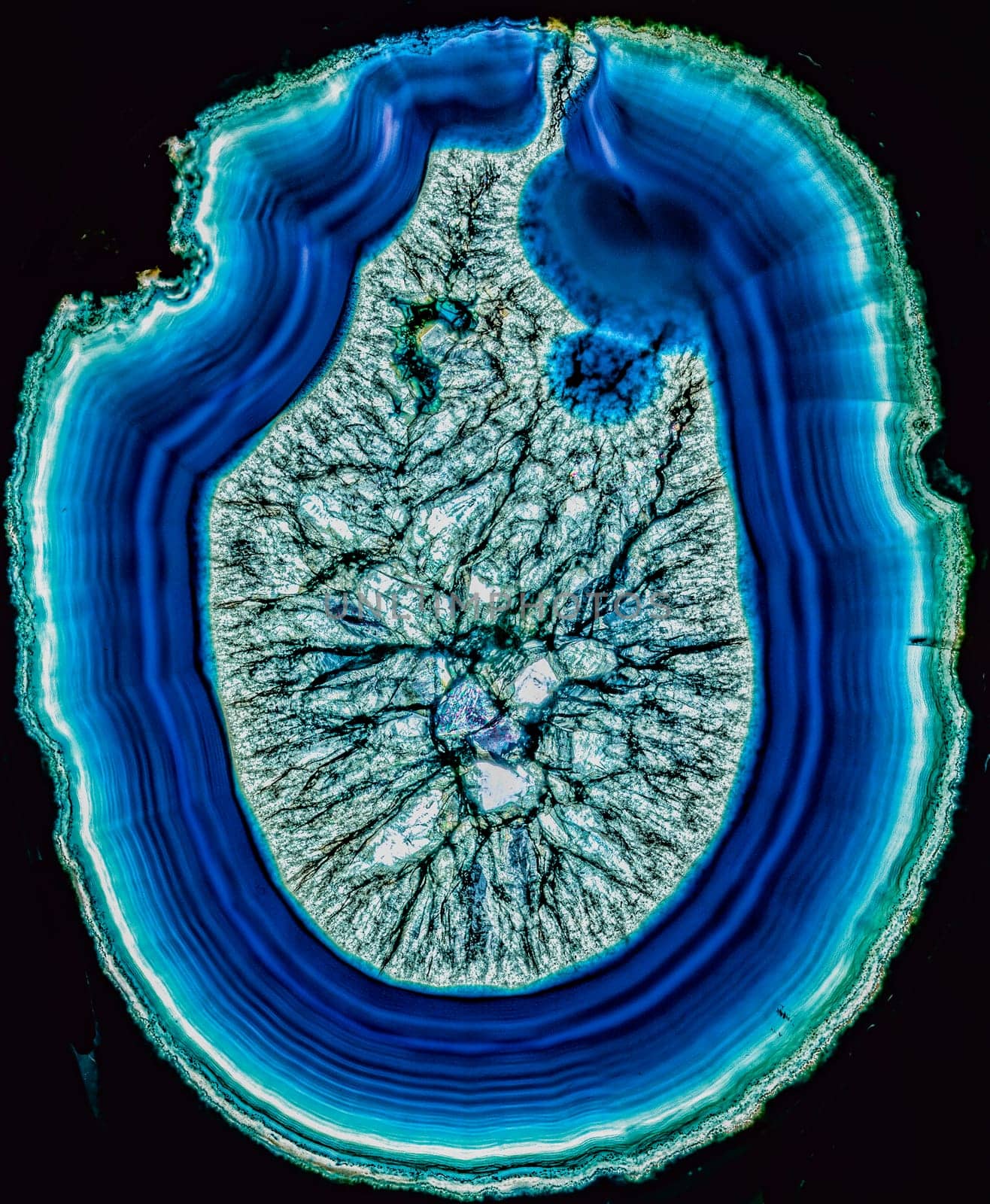 Concept of a volcano breaking through the surface  slice of blue agate through polarized light