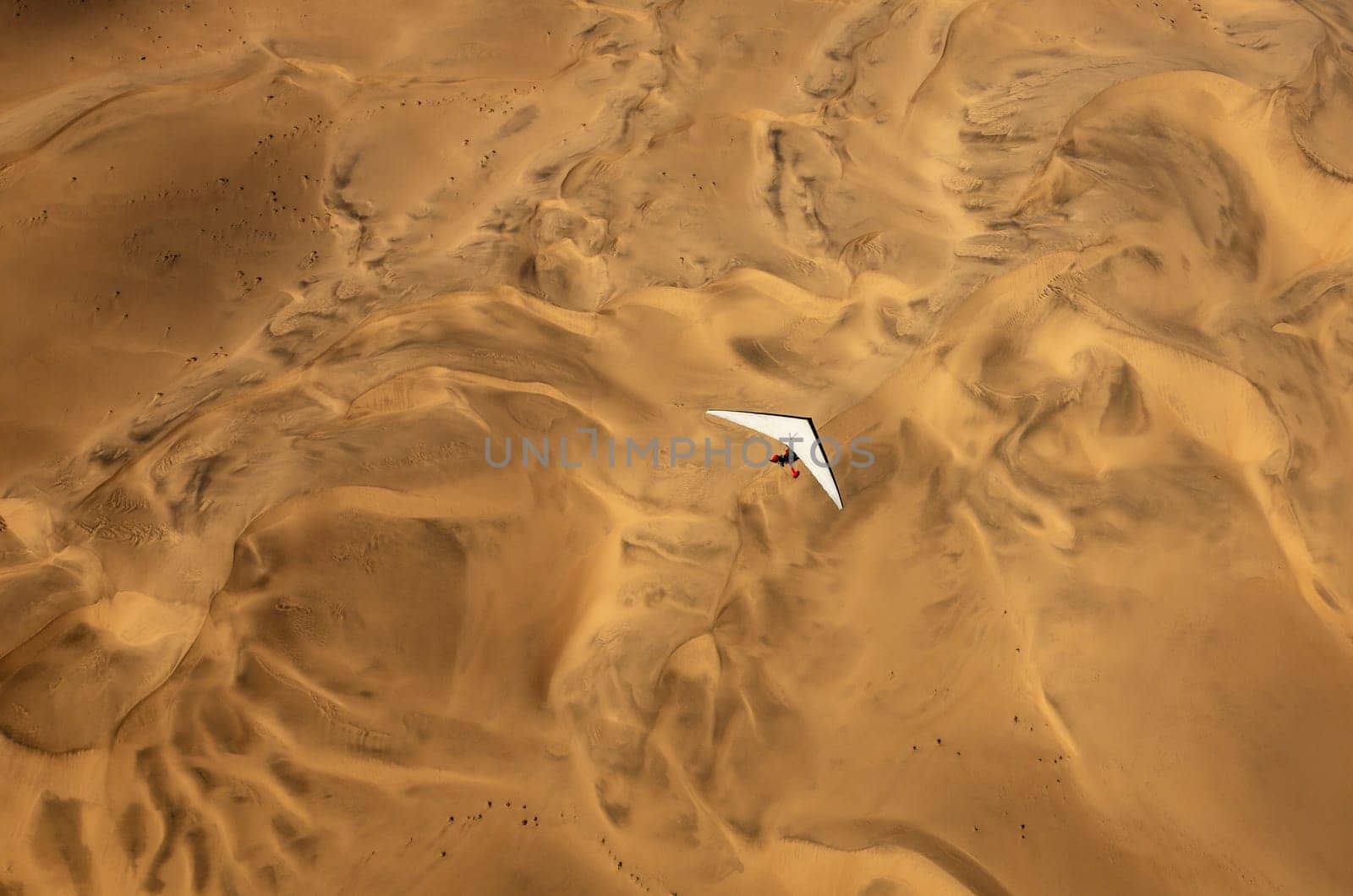 An ultralight aircraft can be seen flying over the sands of Namibia