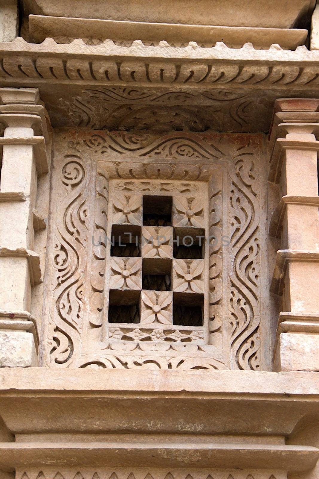 Floral design and square holes of stone window frame at Jain Temple in Khajuraho, Madhya Pradesh, India, Asia