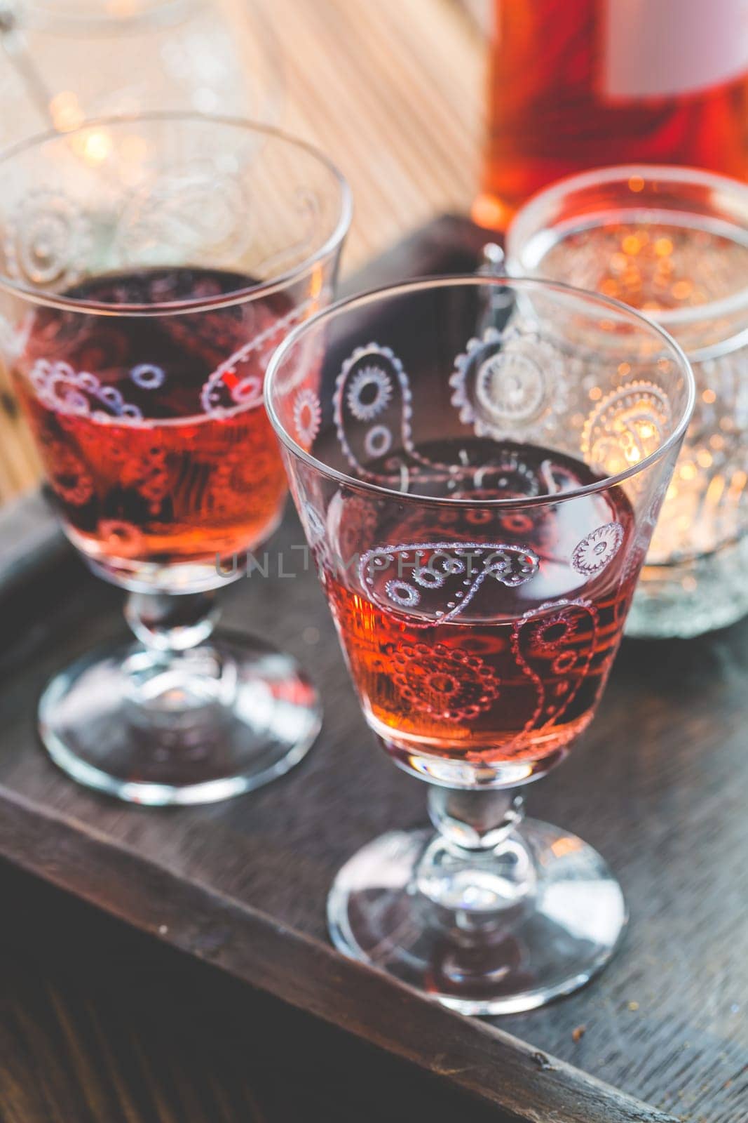 Two vintage glasses of red wine with bottle and lantern on wooden background
