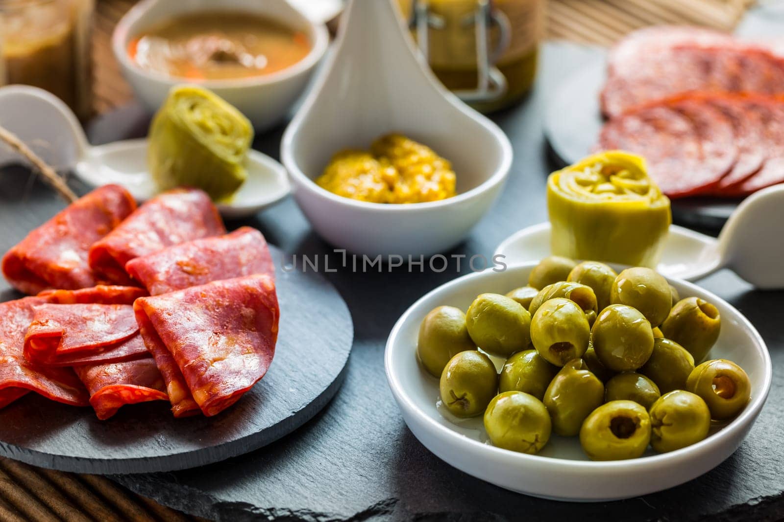 Assortment of tapas and antipasti on black background. Charcuterie boards of assorted appetizers.