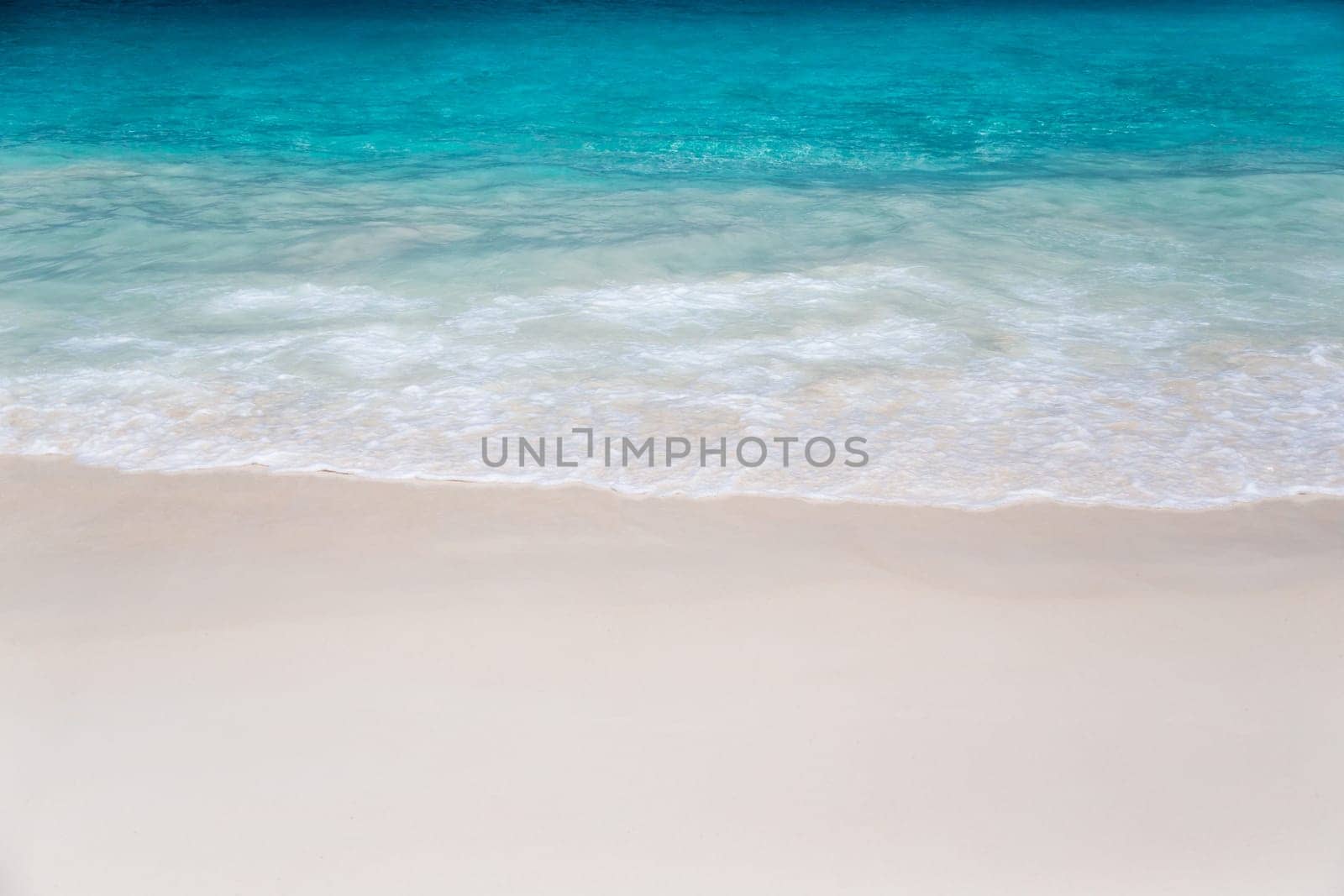 The beach with white sand and turquoise water with waves