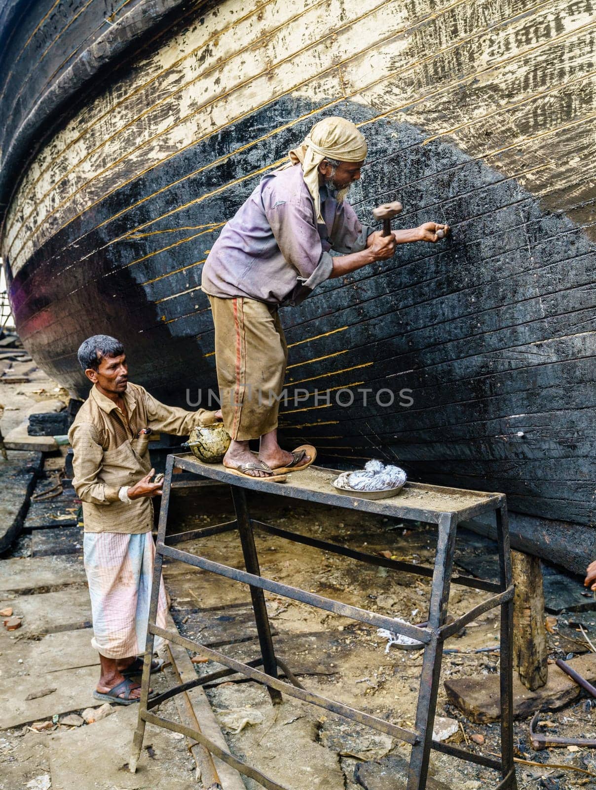Chittagong, Bangladesh, December 22, 2017: Workers are building traditional fishing boats at a shipyard by the Karnaphuli River near Chittagong, Bangladesh