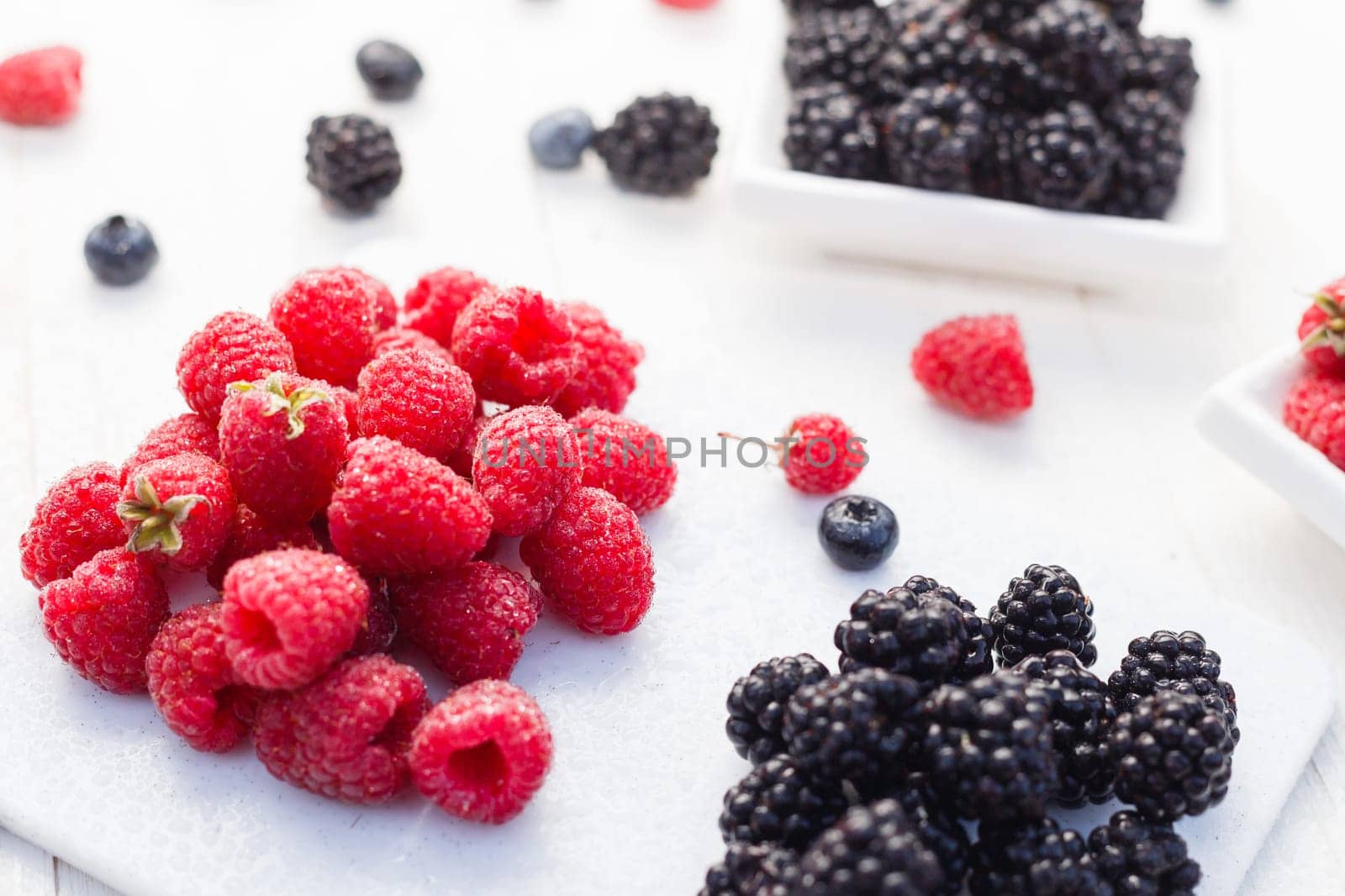 Blueberries, raspberries and blackberries on white background.