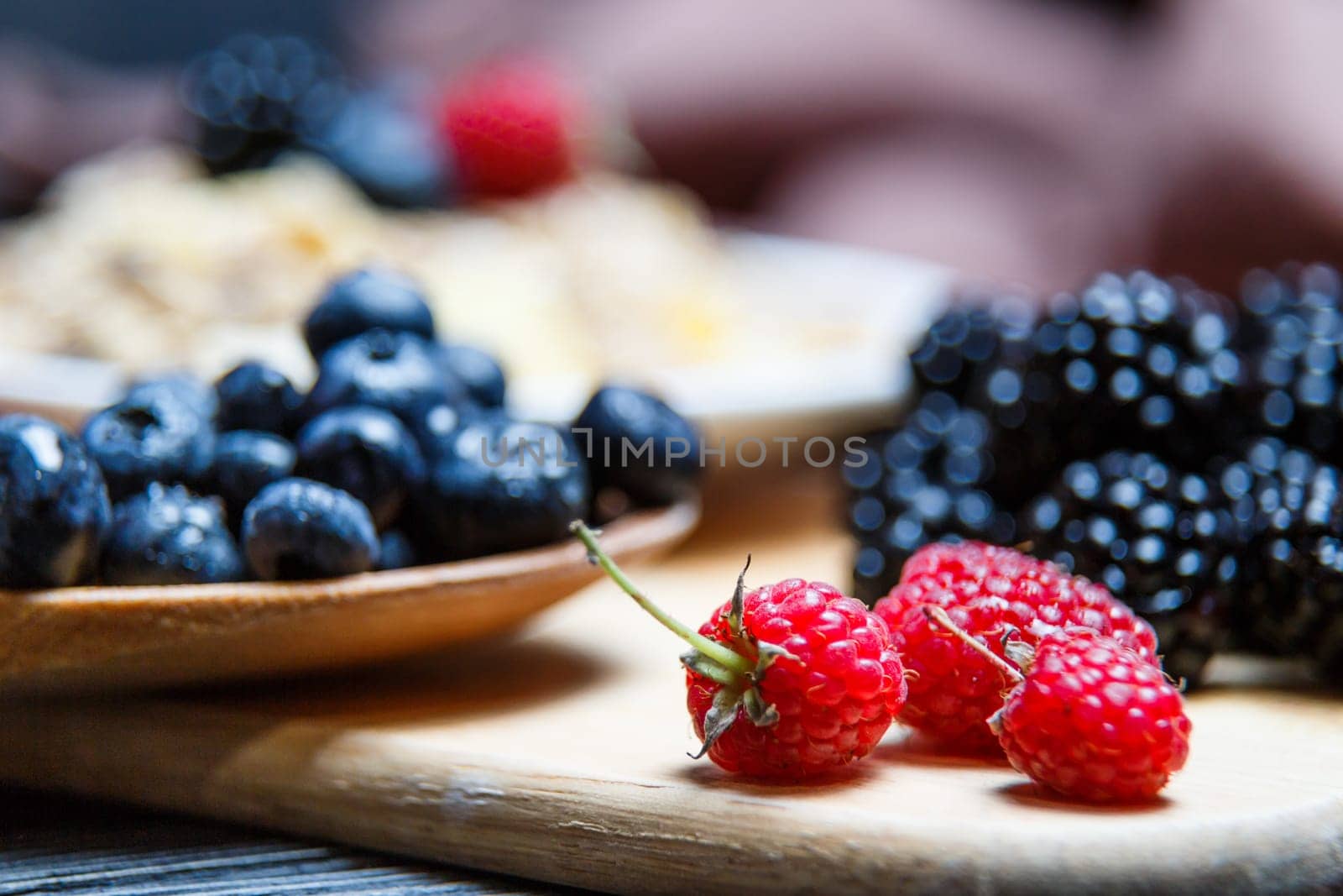 Berries mix blueberry, raspberry on rustic wooden table.