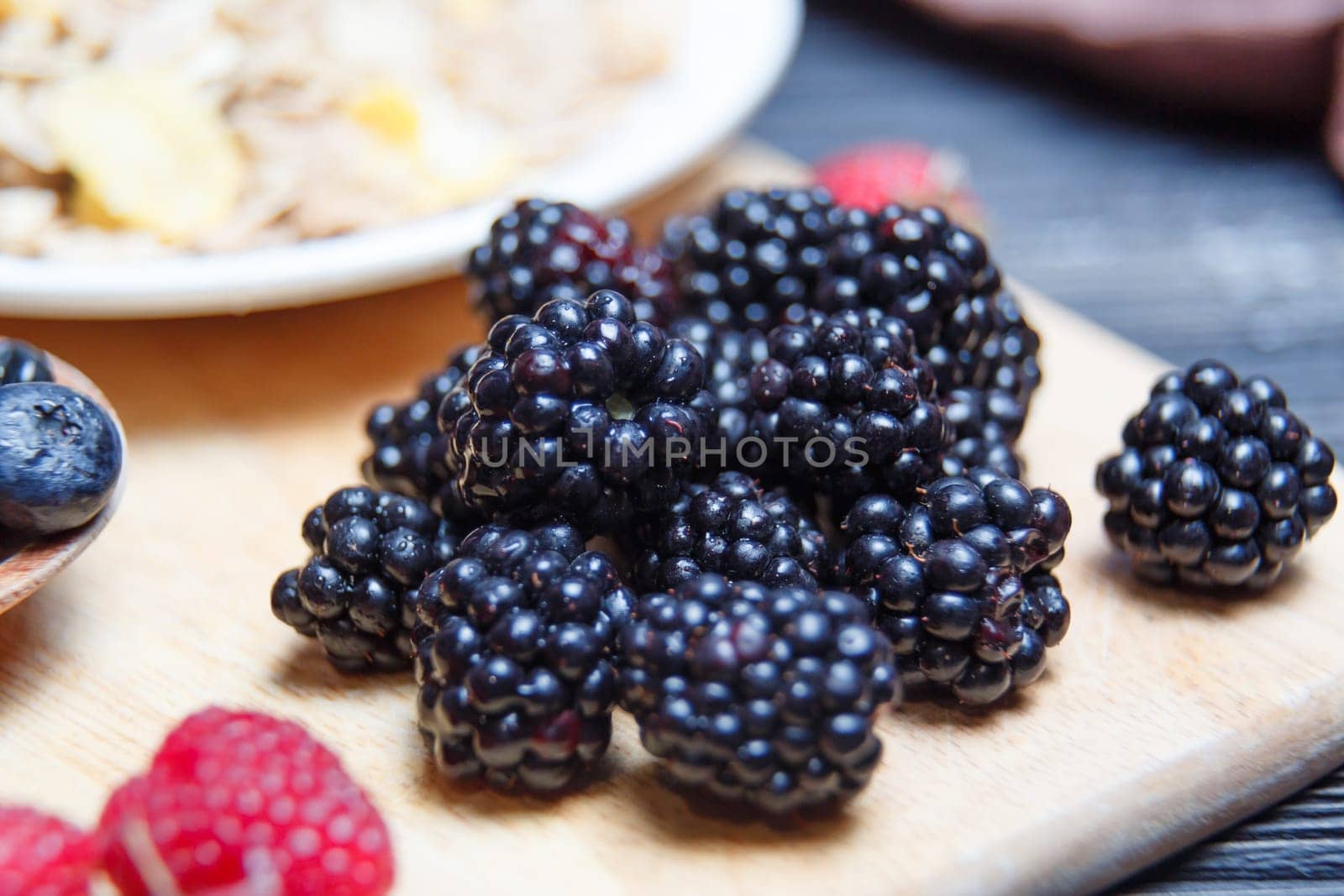 Ripe and sweet blackberries in bowls on wooden table.