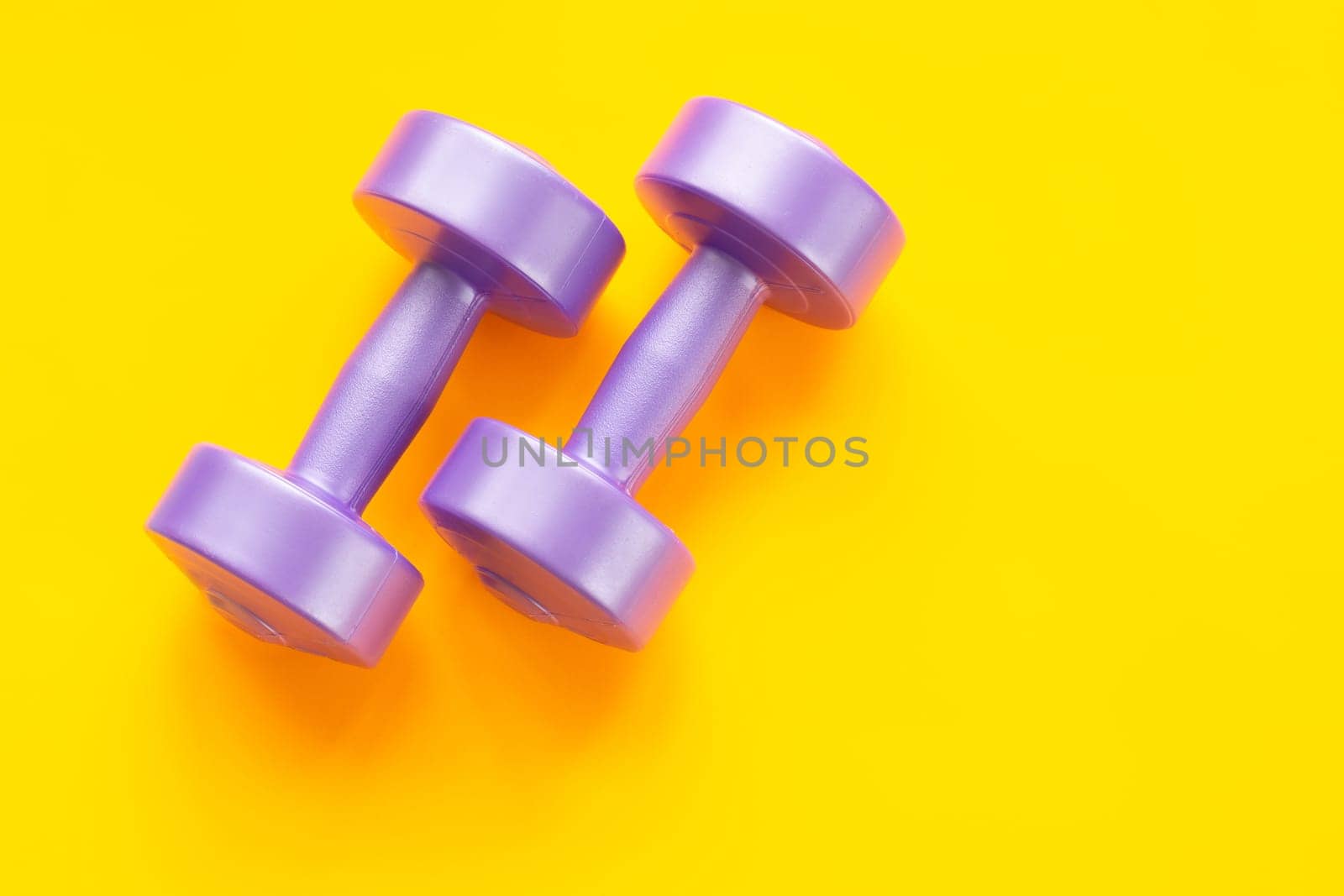 Two purple dumbbells on a yellow background