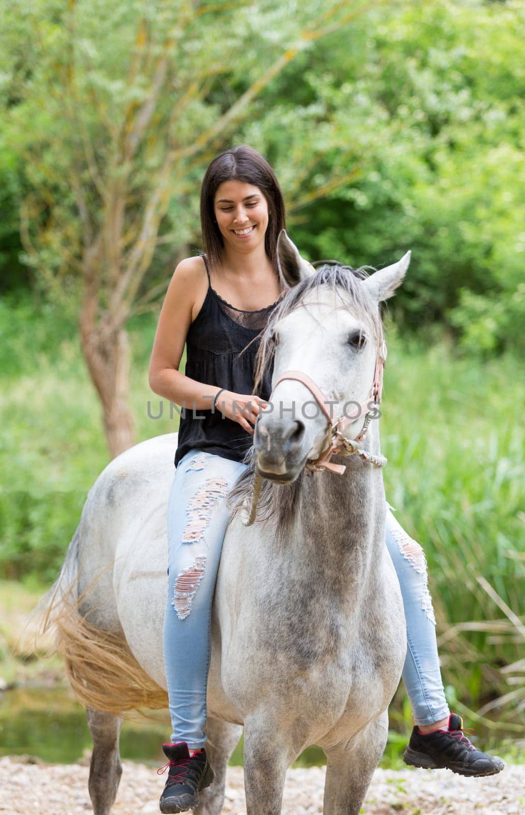 Happy young woman with her horse and strolling