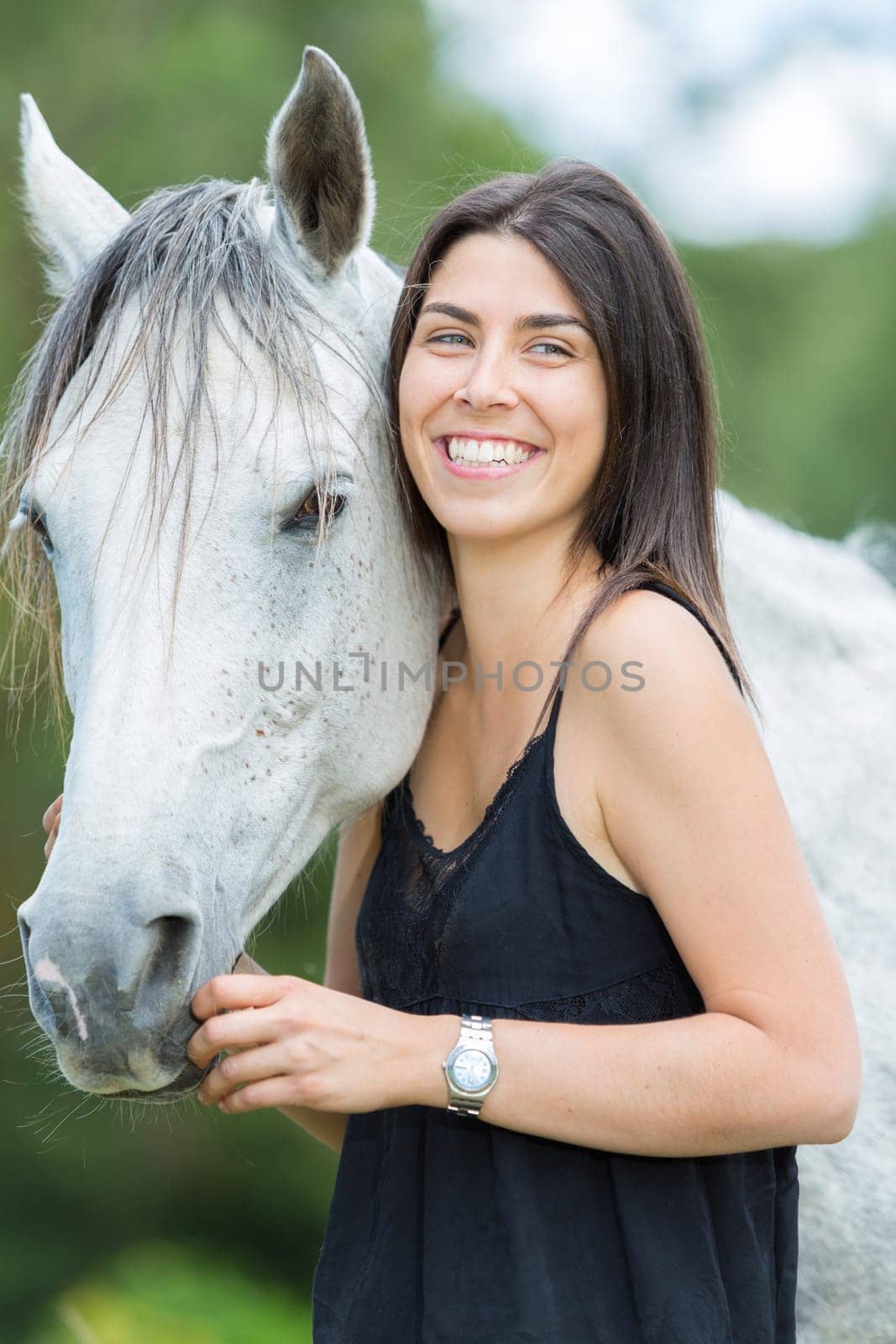Happy young woman with her horse and strolling