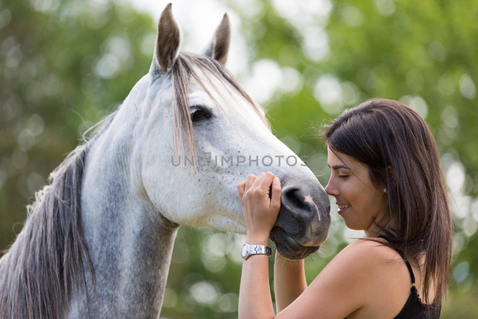 Happy young woman with her horse and strolling