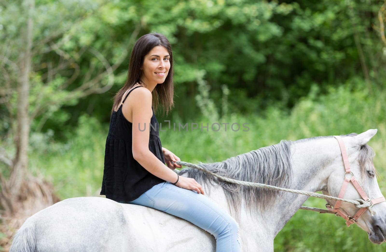 Happy young woman with her horse and strolling