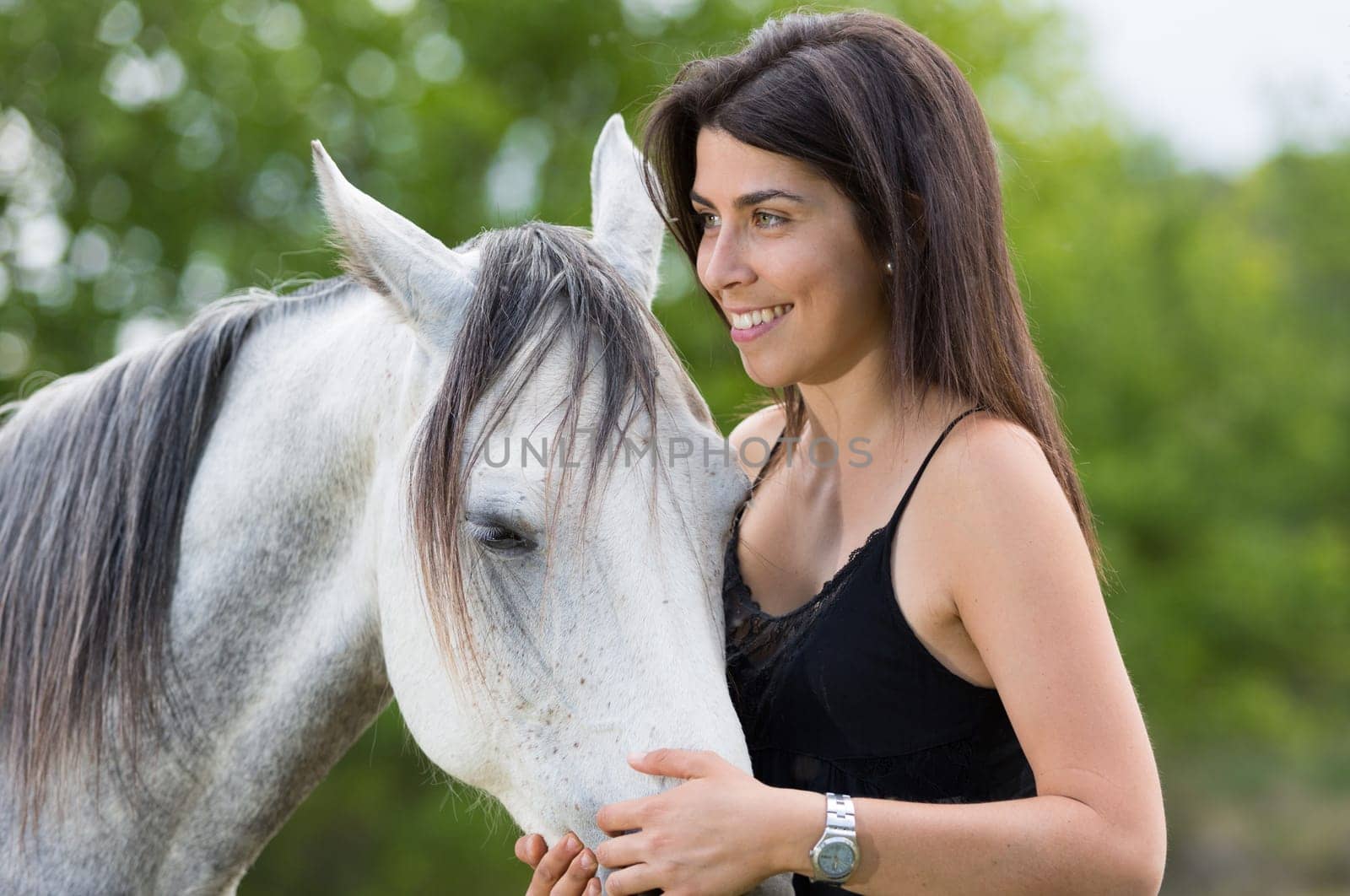 Happy young woman with her horse and strolling